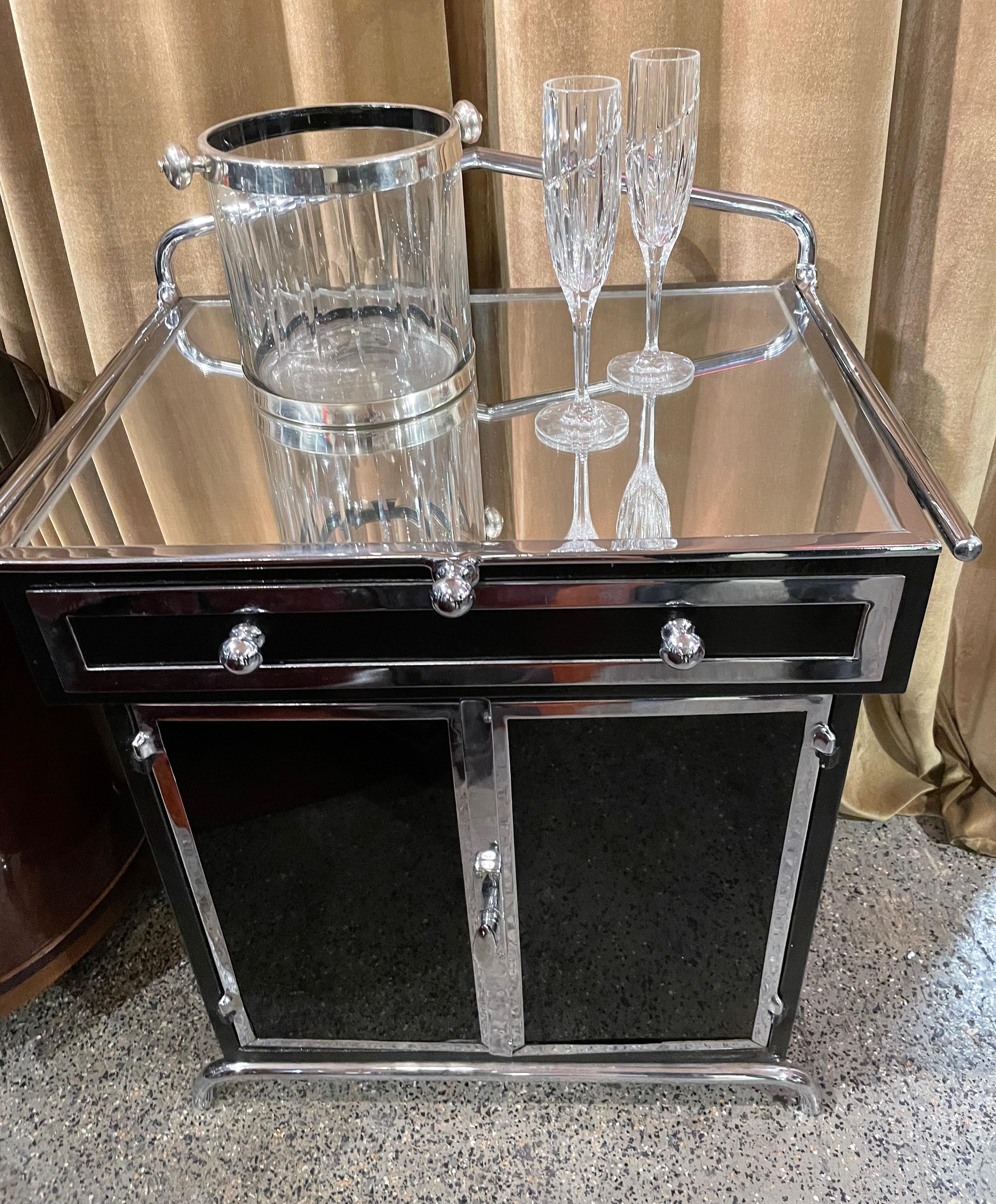 Art Deco bar or display case, a “Vitrine” as it is called in France, fashioned of chrome with black lacquer, glass, and mirrors that is the perfect way to show off some special bar accouterment or a collection. There is plenty of storage in the
