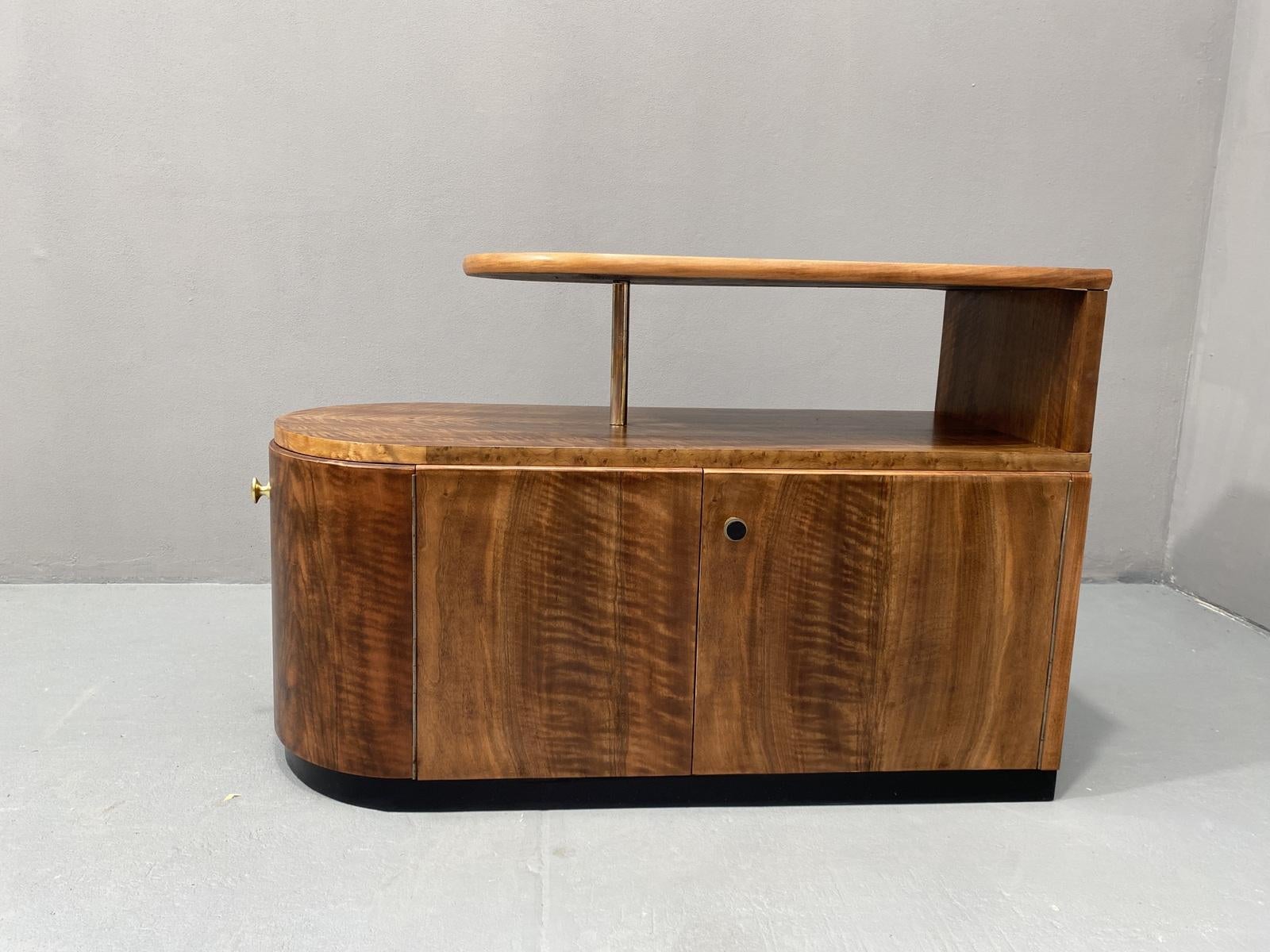 Ce bar ou buffet Art déco est un meuble étonnant qui ajoutera une touche d'élégance à n'importe quelle pièce. Avec son design épuré et son style unique, il ne manquera pas d'alimenter les conversations. Le bar présente un placage en noyer avec de