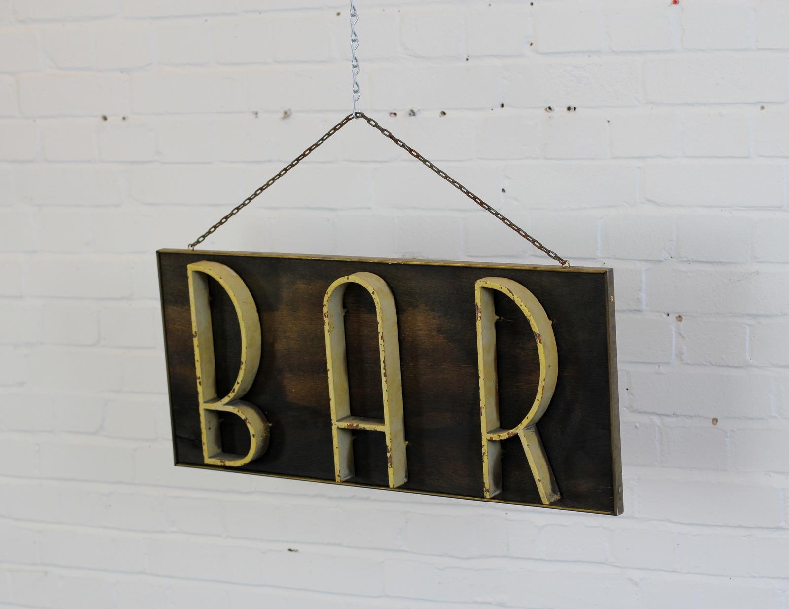 Art Deco bar sign, circa 1920s.

- Oak backboard
- Cast iron letters
- Original cream paint
- Dutch, circa 1920s.
- Measures: 76cm x 35cm x 7cm.

Condition report

Patina consistent with age.