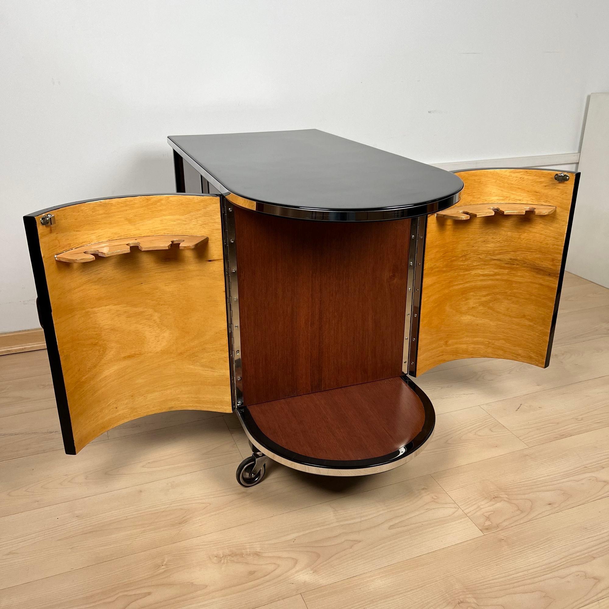 Art Deco Bar Trolley, Black Lacquer, Mahogany, Chrome, France circa 1930
* Black lacquered asymmetrical walnut body
* Two rounded doors at the front, inside in light maple wood lacquered
* Mobile on 4 original wheels
* 2 sliding glass doors on each