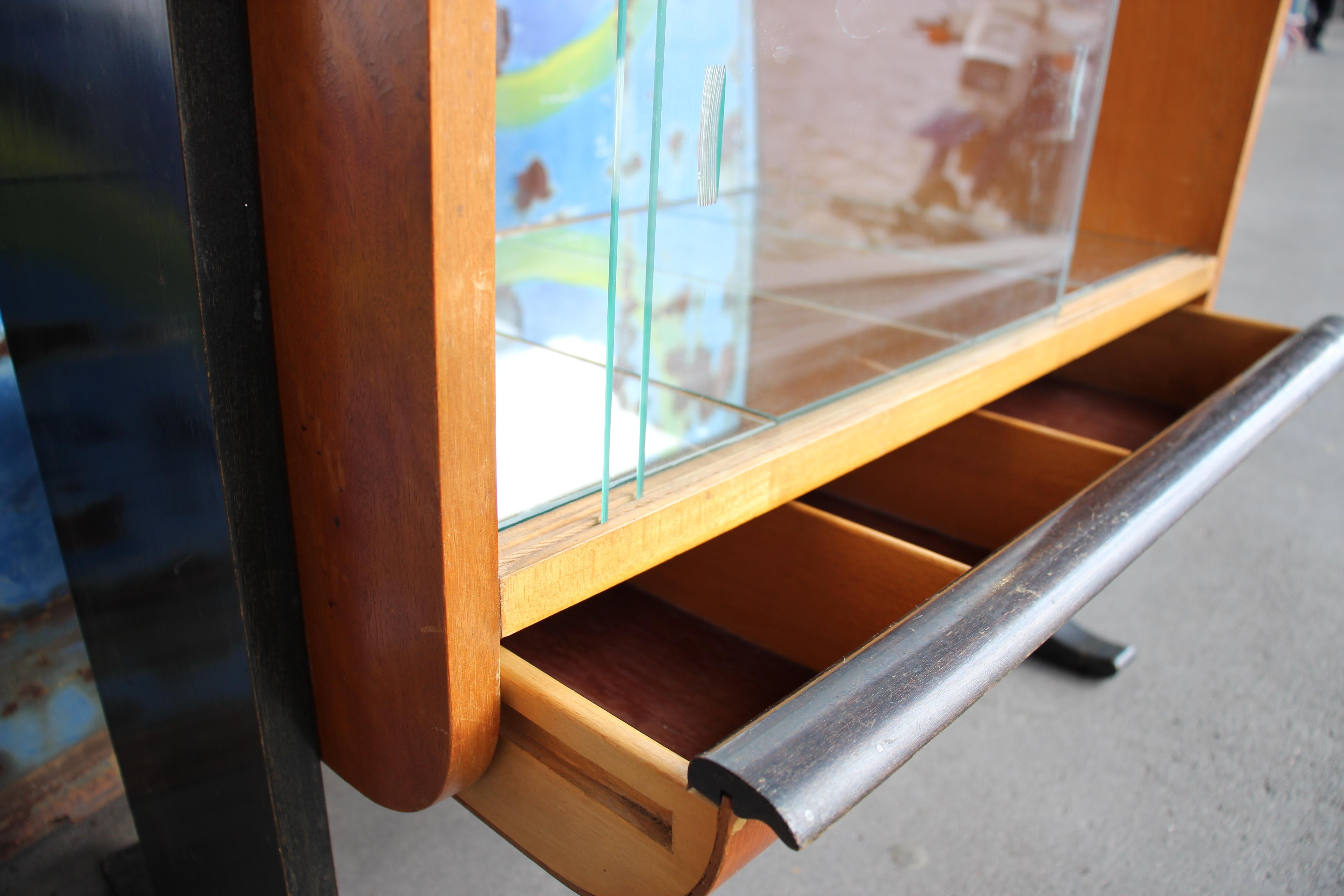 Beech with walnut veneer, side parts/legs black lacquered. Glass top and sides, mirror bottom. Original excellent condition. Designed in the 1930s by Jindrich Halabala for Spojene UP-Zavody, Czechoslovakia.