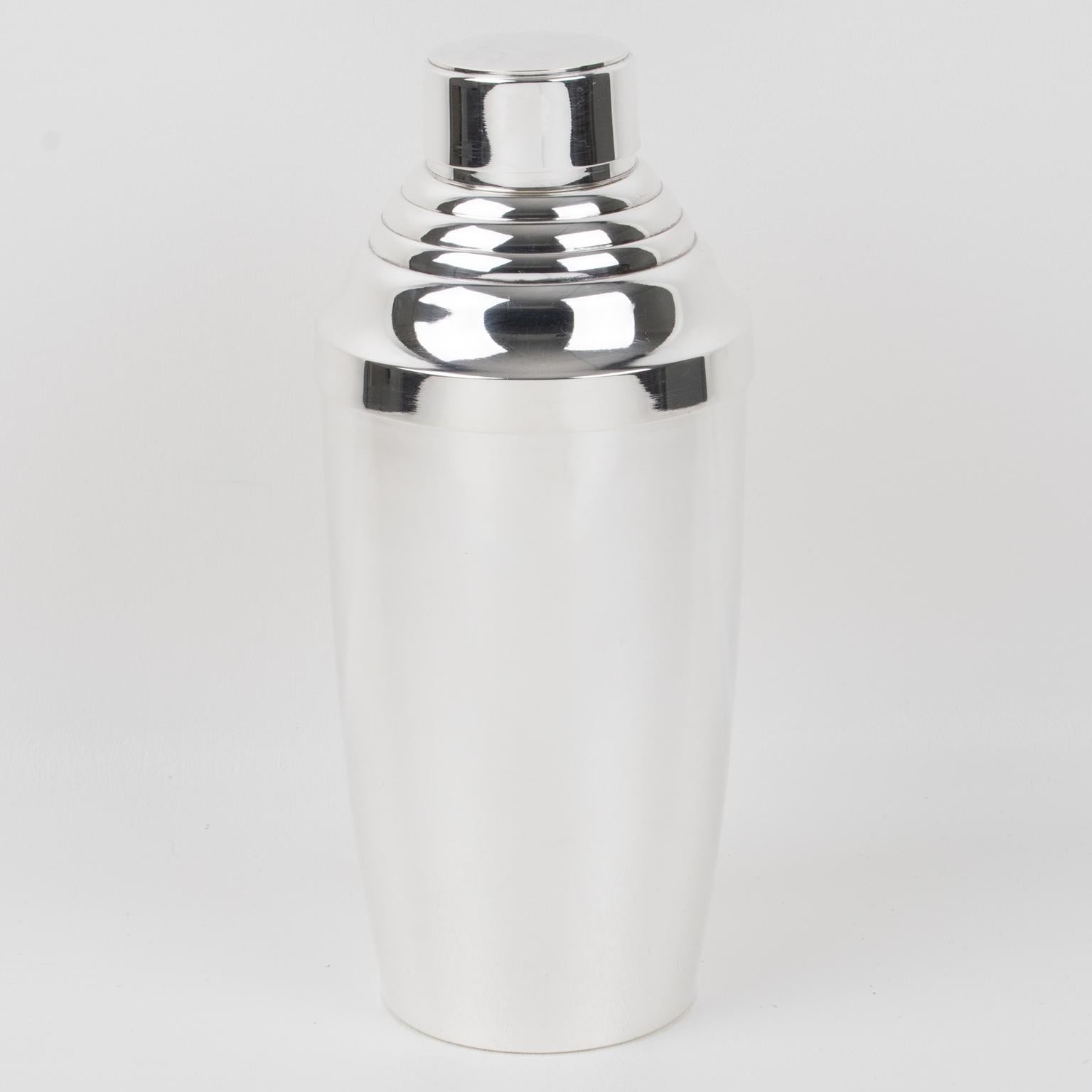This barware serving set is an exquisite example of French Art Deco design, crafted from silver plate metal by Silversmith Maison Barra of Paris in the 1940s. The three-sectioned designed cylindrical Martini or cocktail shaker has a removable cap