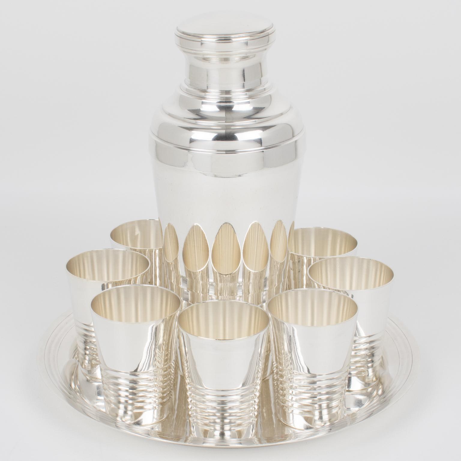 Silversmith Roux-Marquiand, Paris, designed this elegant Art Deco silver plate barware serving set in the 1940s. The three-sectioned designed cylindrical cocktail or Martini shaker has a removable cap and strainer. The set is complemented with eight