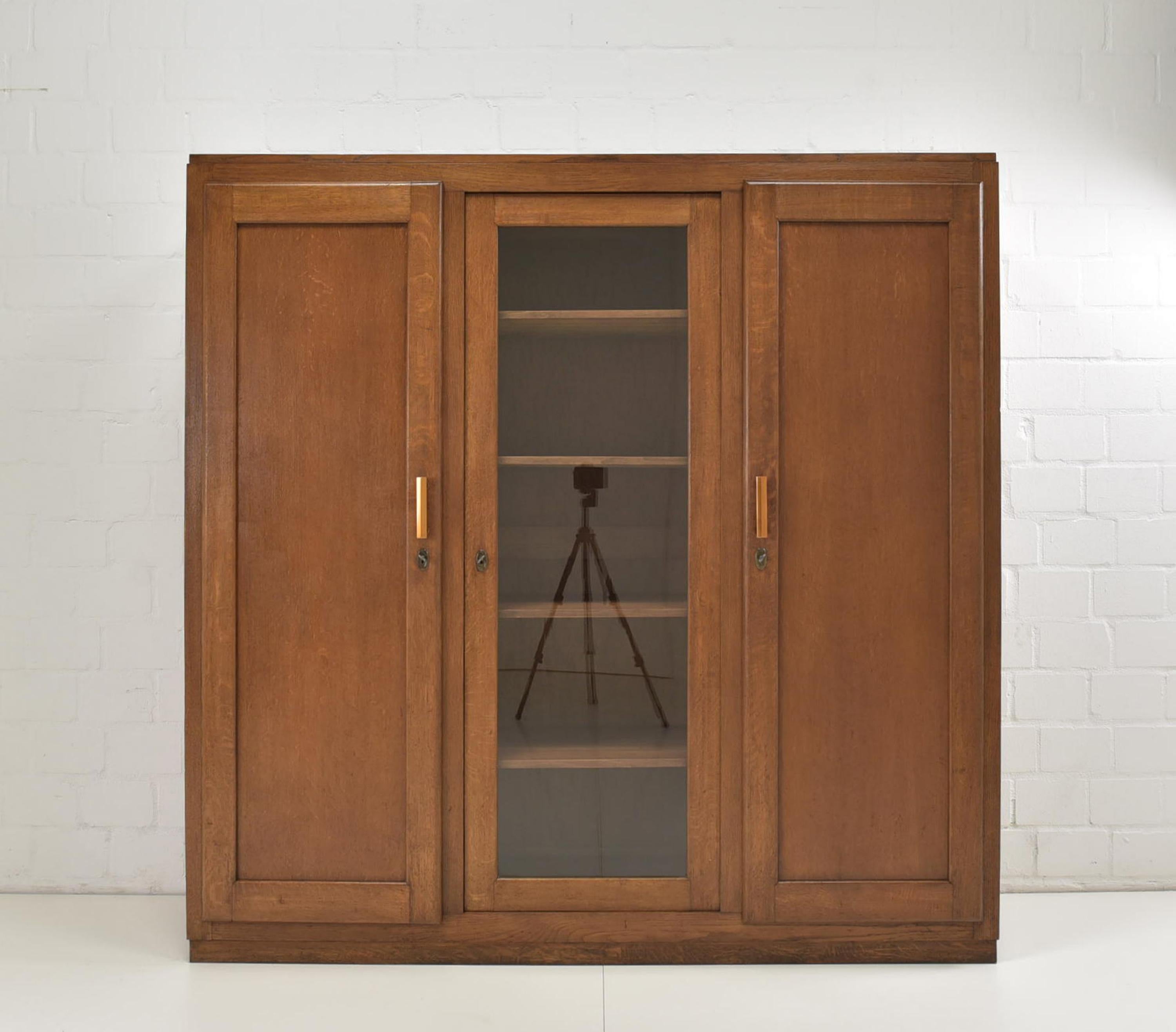 Bookcase restored Art Deco Bauhaus around 1935 oak display cabinet

Features:
Partly solid oak
Three-door model with 10 shelves
Geometric shape
Timeless, functional design
The cabinet can not be dismantled

Additional information:
Material: Partly