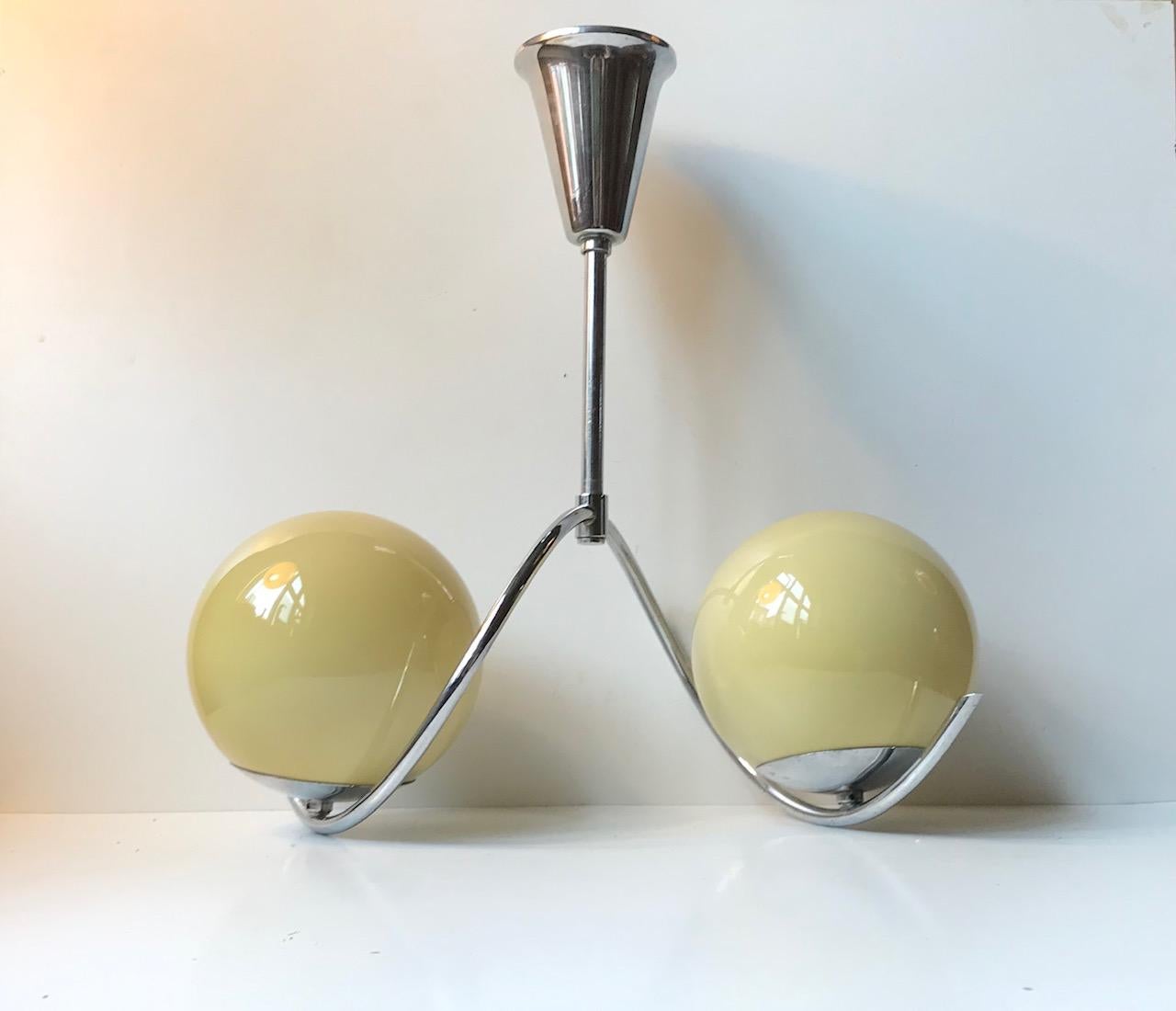 Sculptural Bauhaus chandelier executed in chrome nickel-plated brass. It features its original shades in yellow opaline glass and its original canopy. Manufactured and designed by Ernest Voss in Denmark during the 1930s in a style reminiscent of