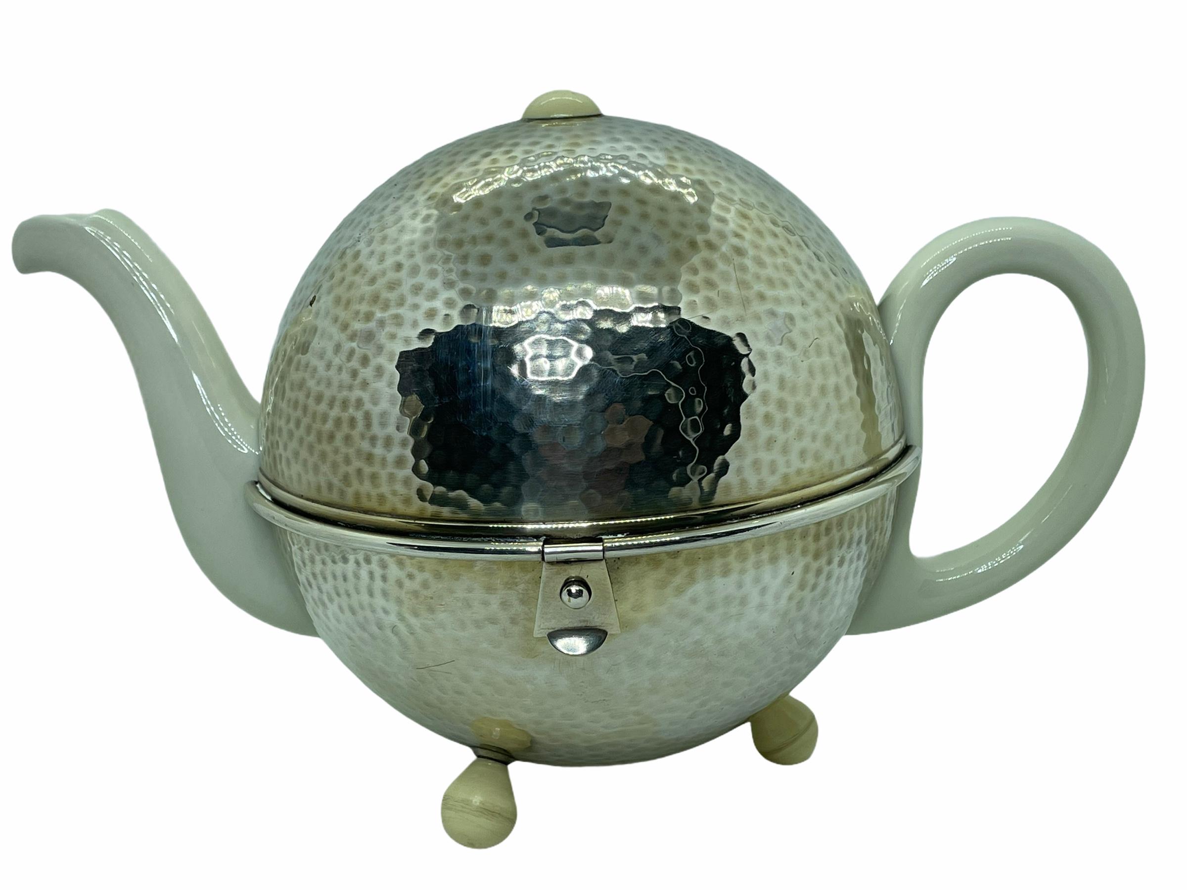 Art Deco Bauhaus Hutschenreuther tea pot hammered WMF metal cozy This handsome vintage tea pot marked Hutschenreuther Bavaria Germany is snugly nestled in a WMF D.R.P. hammered silver-clad over copper cozy, and lined with a charcoal grey wool felt.