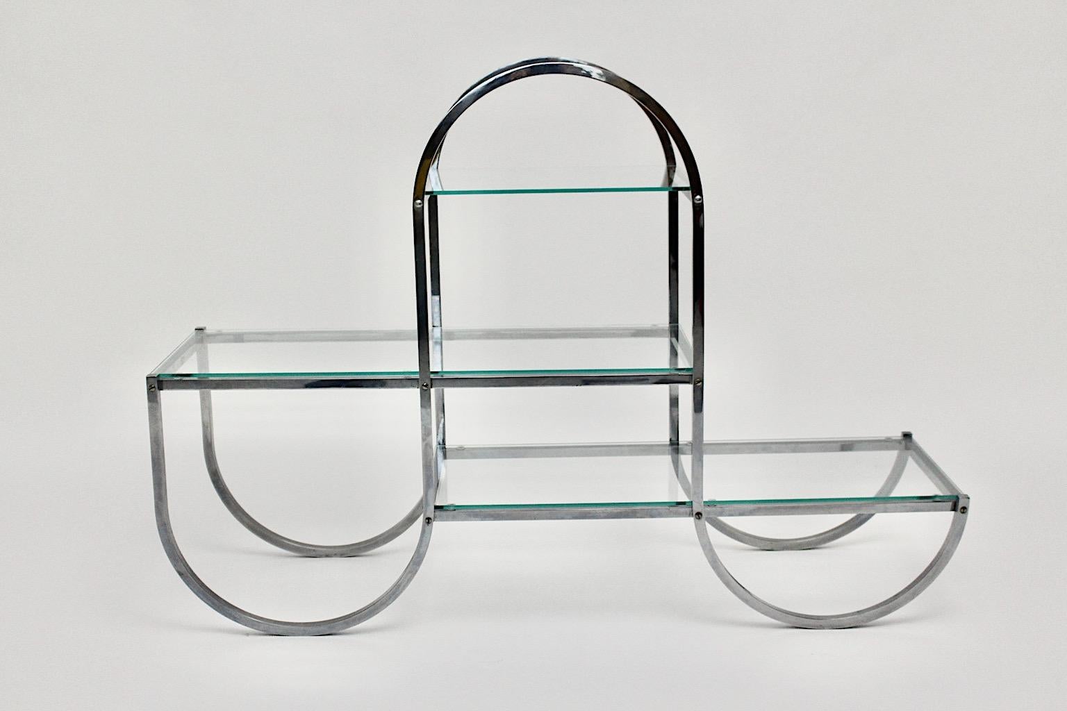 Art Deco Bauhaus vintage flower stand or book stand or room divider or shelves from chromed metal and clear glas plates, which was designed 1930s, Germany.
The flower stand shows a curved tube steel construction with three clear glass plates.
Art