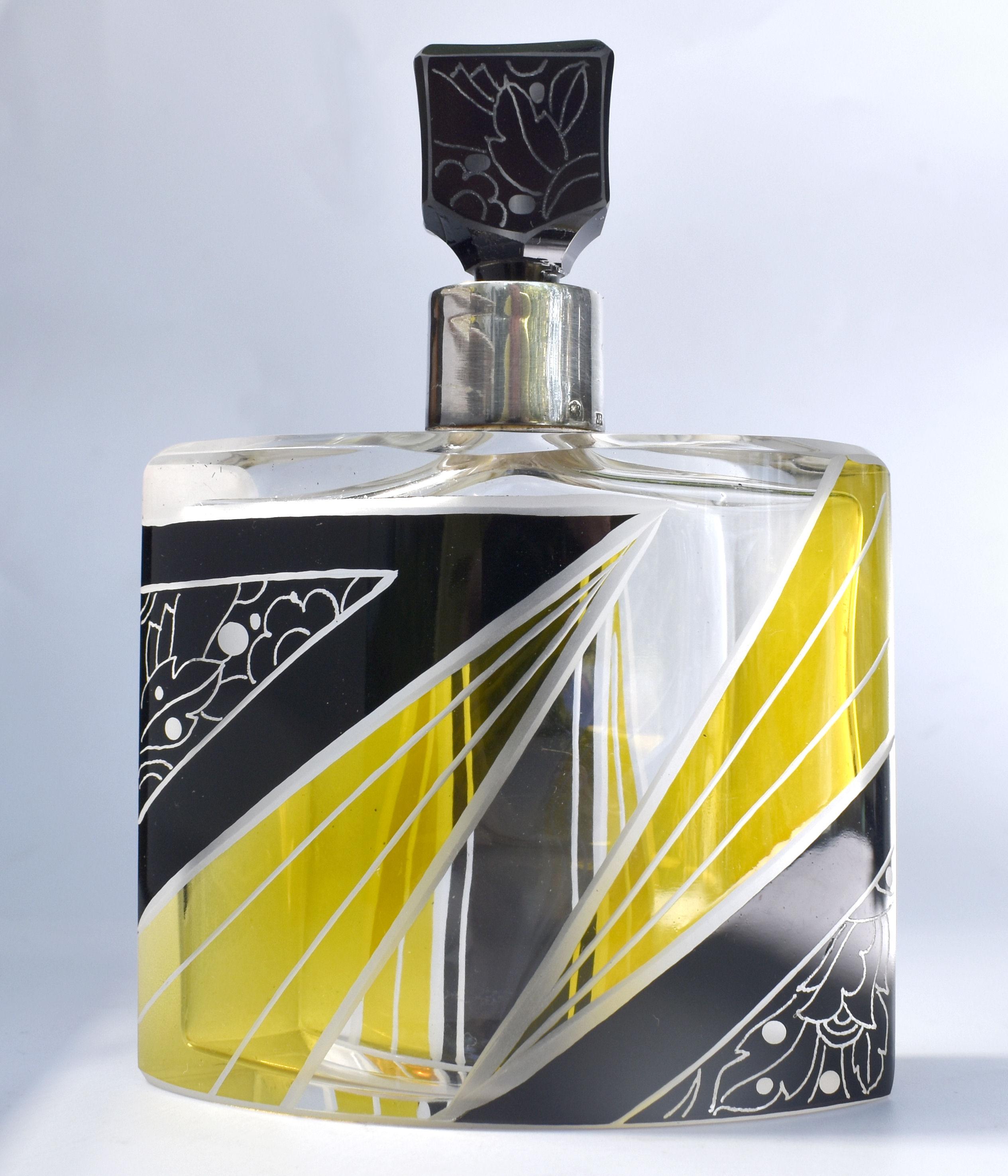 This perfume bottle is an absolute delight in every aspect. From the unusual crescent shaped body with it's vibrant lemon yellow and jet black enamel decoration in the form of lightening bolts. To the acid etched detailing to the glass stopper and