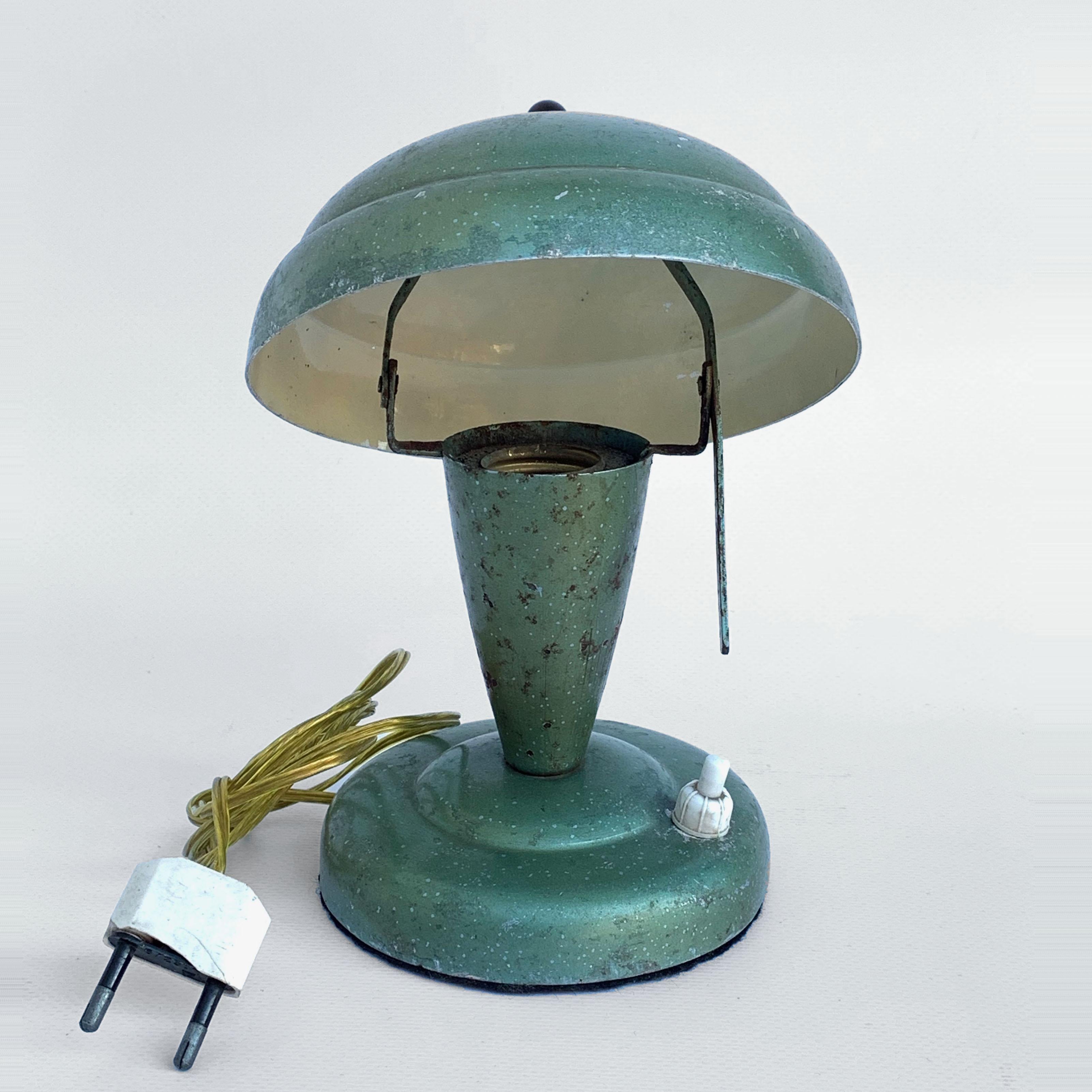Adorable Art Deco bedside lamp presumably produced by Fog & Mørup in Denmark. Base and lampshade in green painted metal. The shadow can be tilted on either side of the center. Recharged but retained the original sockets of the Bakelite lamp holder