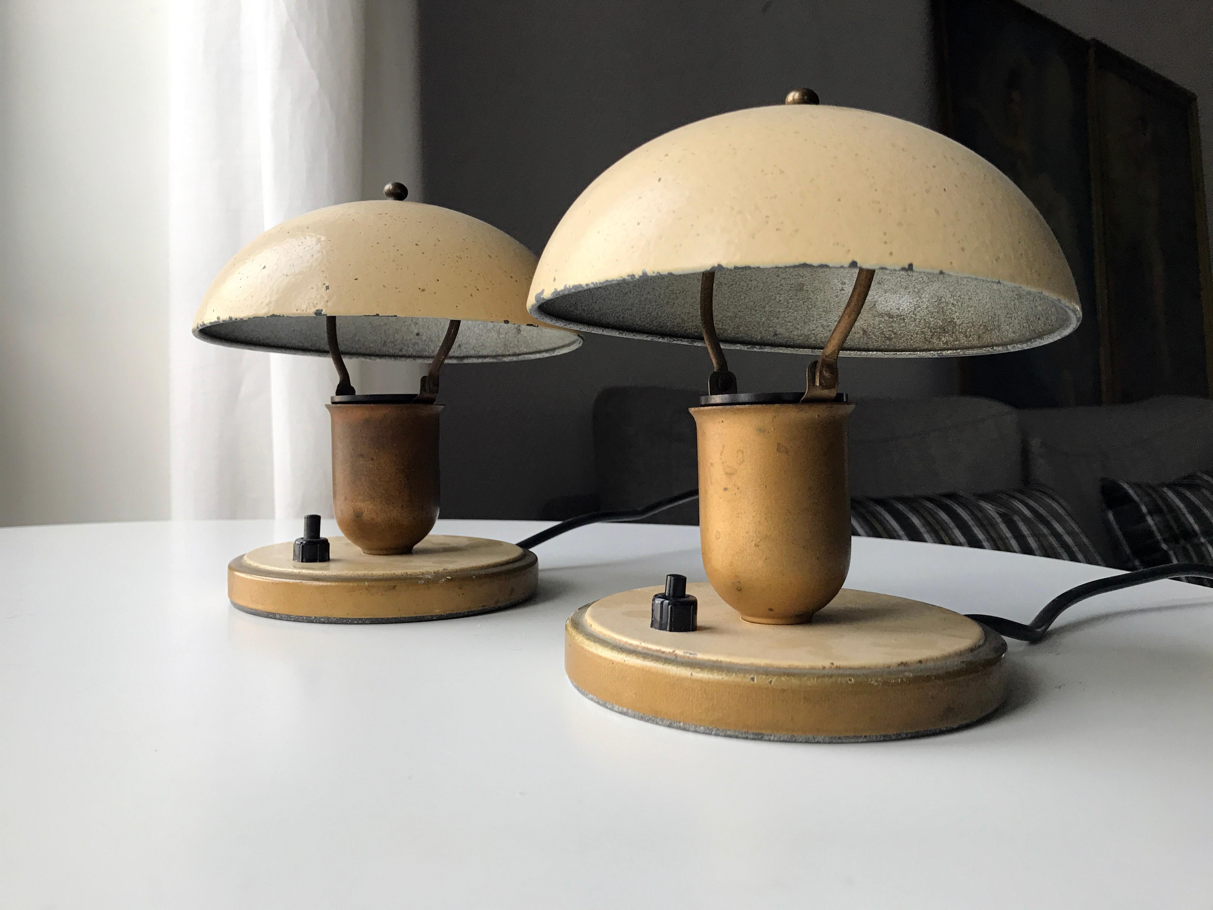 Pair of early art deco bedside table lamps presumably manufactured by Fog & Mørup in Denmark. Base and shade in metal with yellow coating. Shade can be tilted to both sides of the center. Can be placed on table or mounted on wall. Rewired but kept