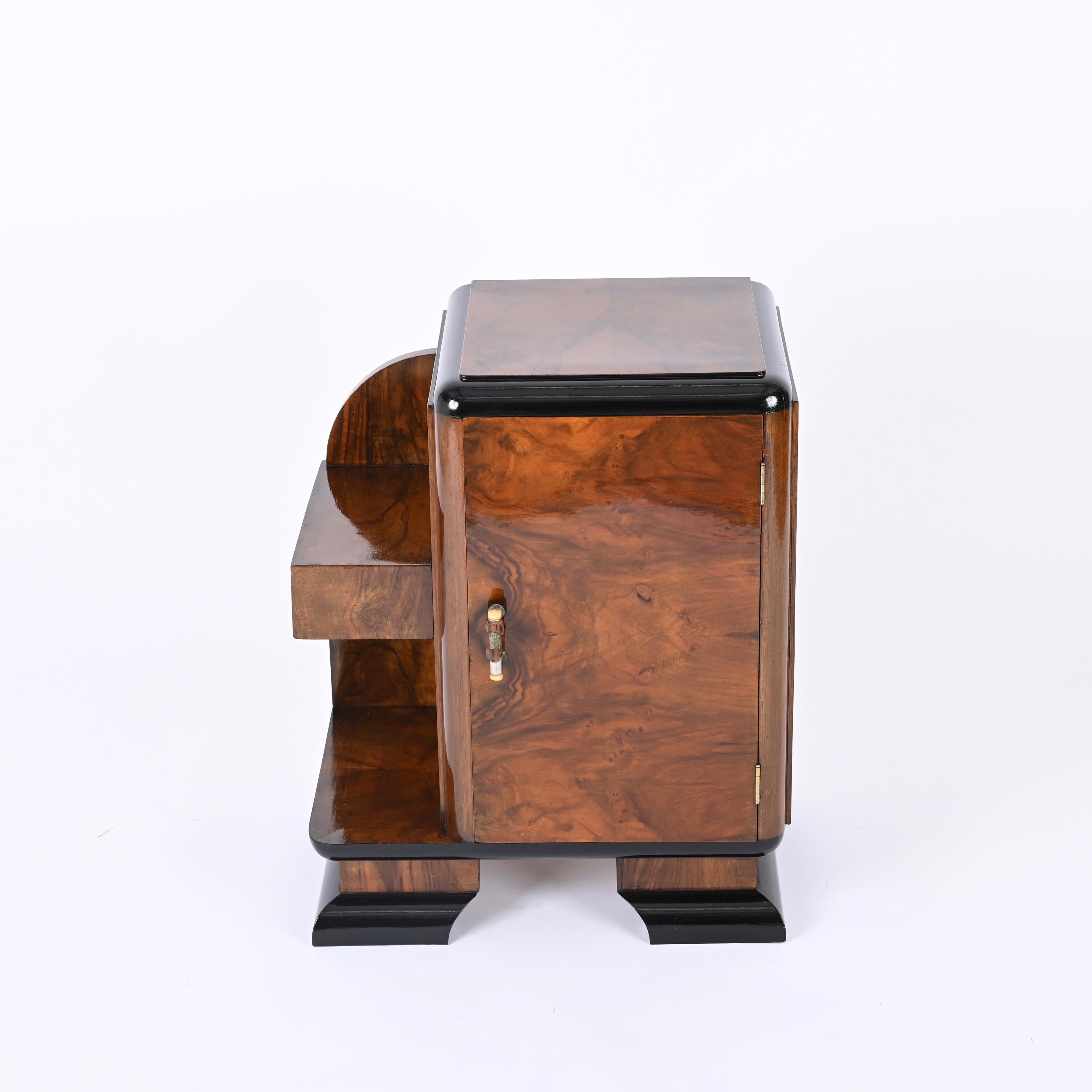 Fantastic Art Deco nightstand or side table in briar wood and black laquered walnut. This outstanding piece was made in Italy during the 1930s.

This elegant nightstand features a body and a top in a fantastic olive burl, the feet and the edges are
