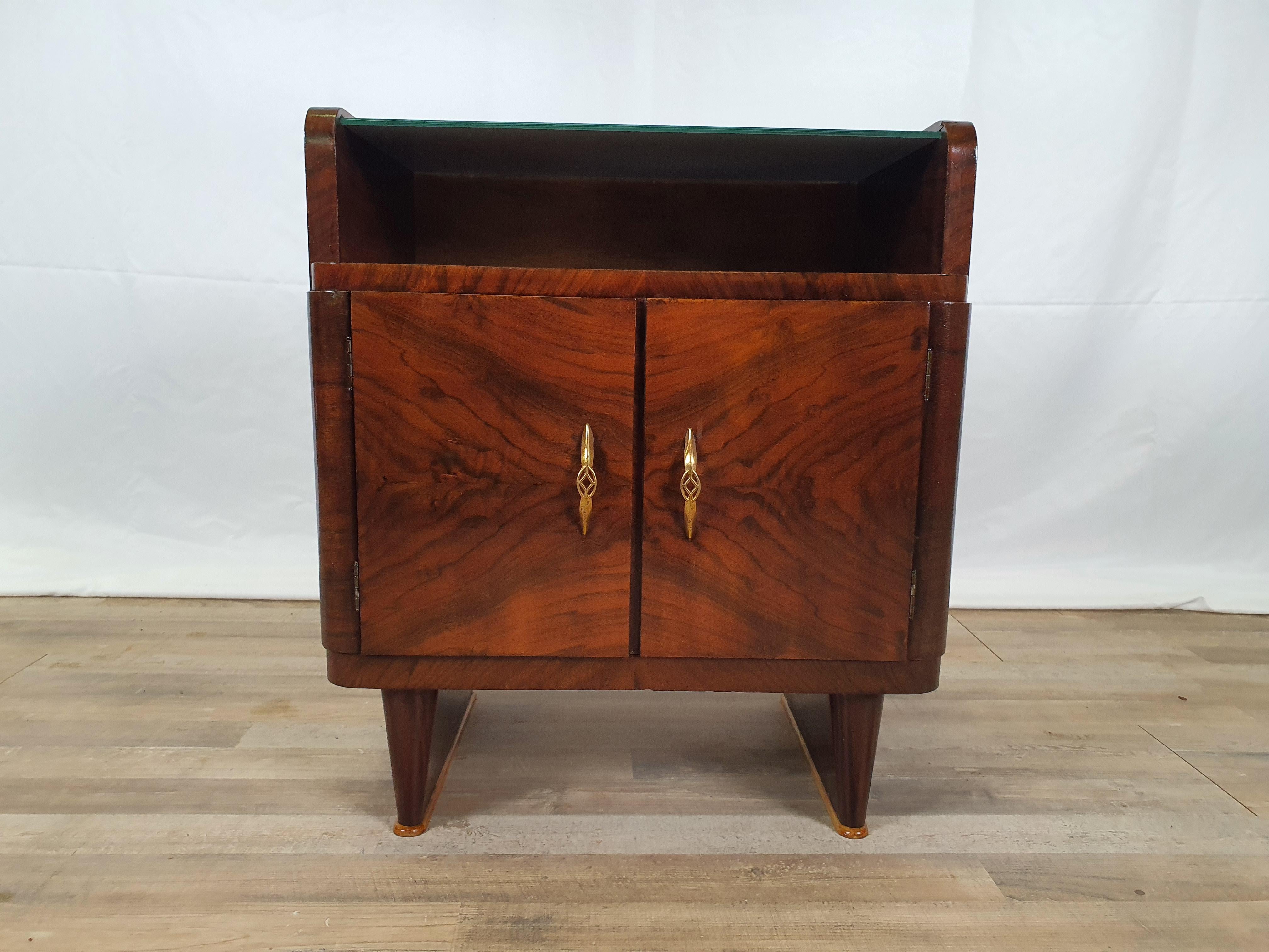 Elegant single bedside table from the 1940s in briar with double door and worked and decorated brass handles.

On the upper floor there is an interlocking mirror, very scenographic and fine.

The bedside table has been polished with oil and