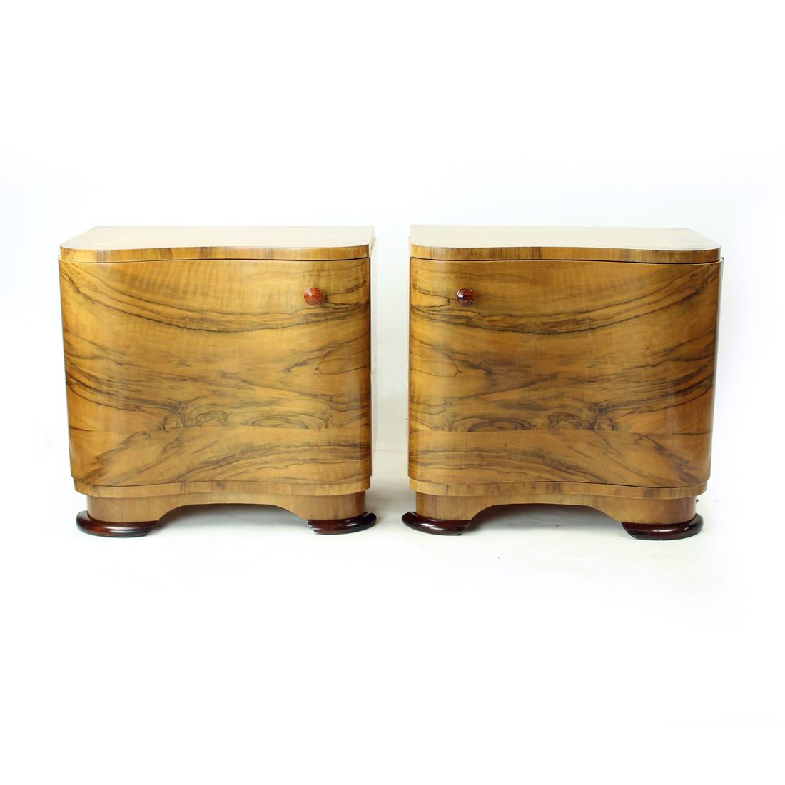 Set of two beautiful bedside tables from art deco era. They are trully unique in their design and use of veneer. The tables are made of oak wood with walnut veneer finish. The beautiful curvy design of the front makes them a stand out pieces. Each