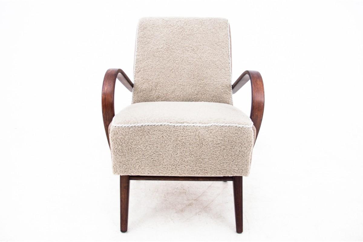 Fauteuil extrêmement confortable de style art déco, fabriqué vers 1930. L'assise et le dossier sont revêtus d'un agréable tissu bouclé. L'ensemble repose sur des pieds droits, et des accoudoirs en bois courbé ajoutent du style. Très bon état, après
