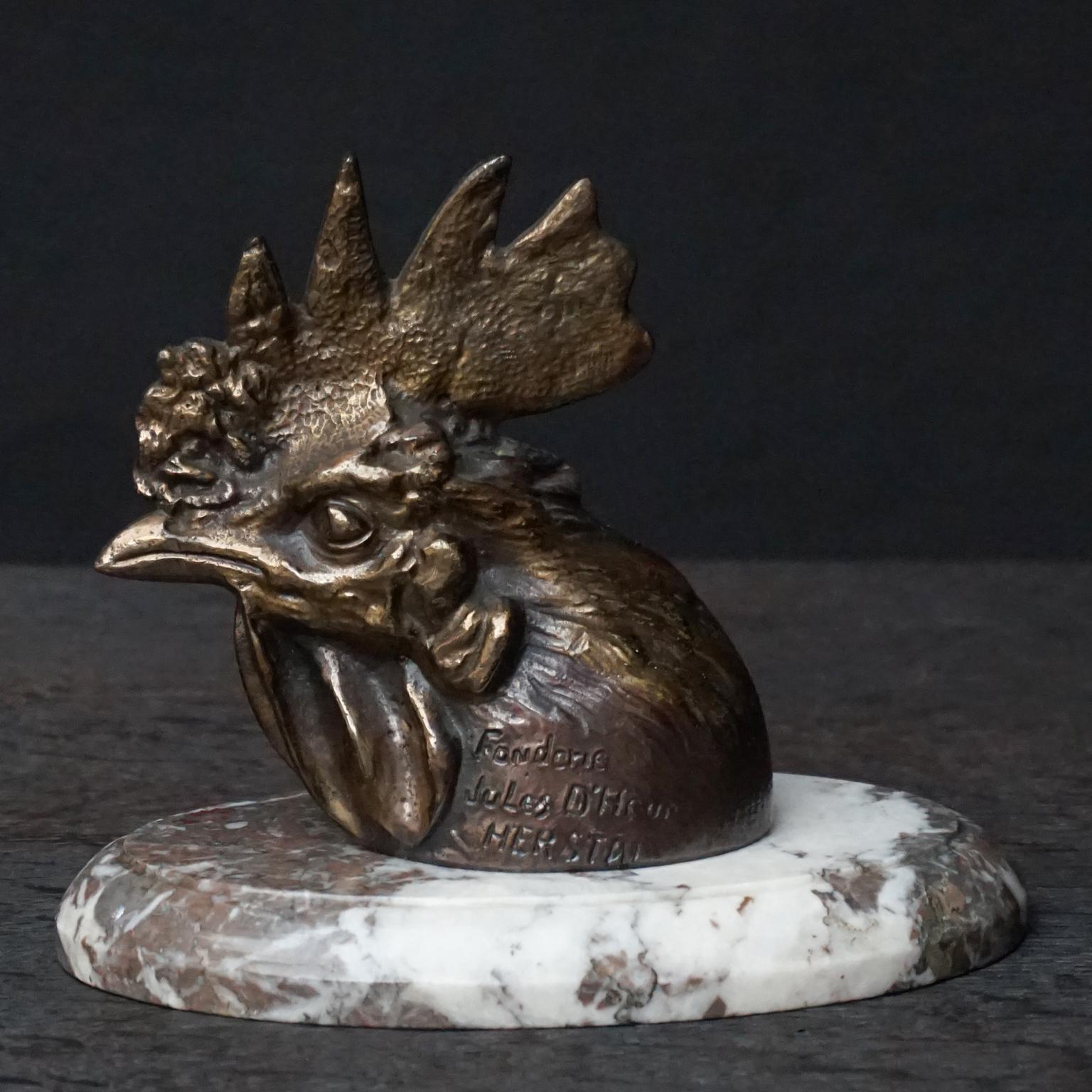 Solid bronze rooster or coq's head cast by Fonderie Jules D'Heur commissioned and cast in Belgium Herstal on a marble base.
Marked fonderie Jules D'Heur HERSTAL

Nice grounding piece for a stack of books.
  