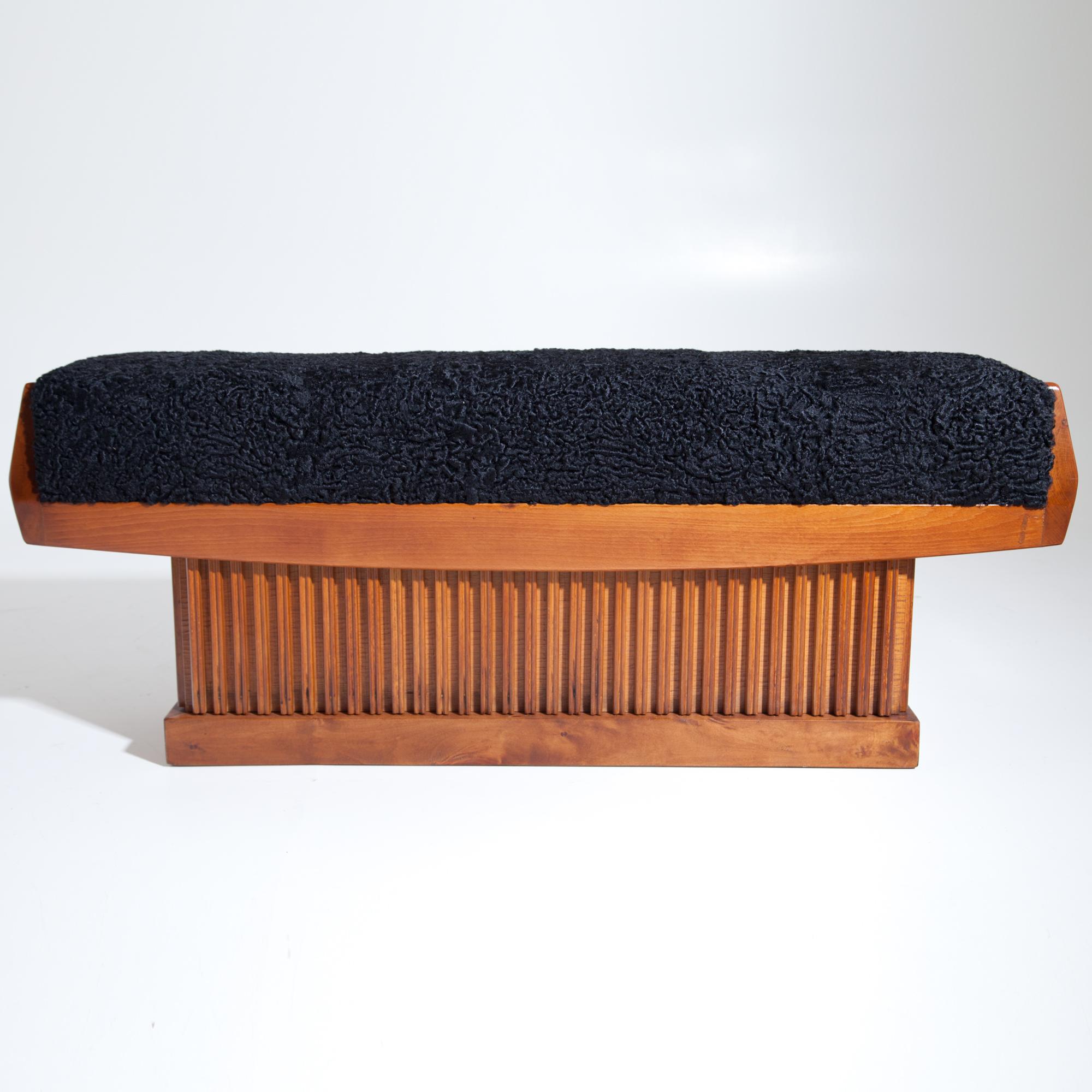 Long bench on block foot with vertical slats. The bench was newly covered with a black Persian fur.