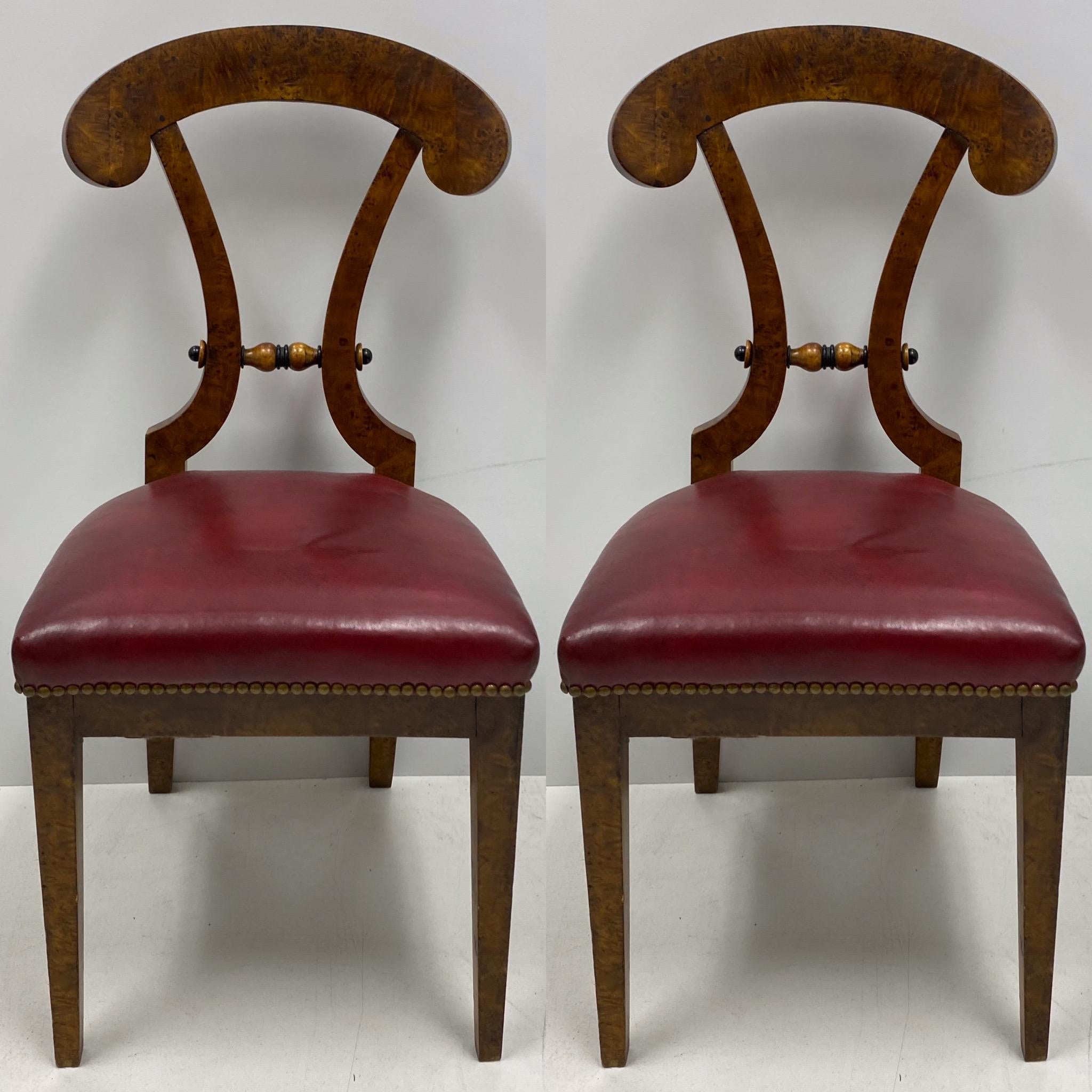  These handsome Art Deco Biedermeier chairs have carved burl wood frames and original deep red leather seats. They date to the earlier part of the 20th century, and they are in original condition.