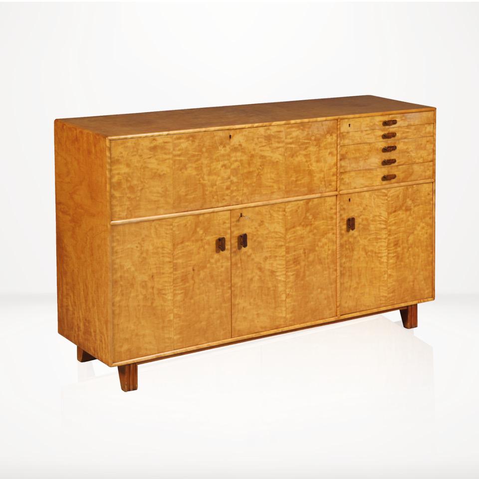 This rare 1930s cabinet in birchwood veneer was designed by Axel Larsson and produced by A.B. Svenska Möbelfabrikerna in Bodafors, Sweden.

The cabinet has two double doors and one single door with five external drawers and one drop down shelf.