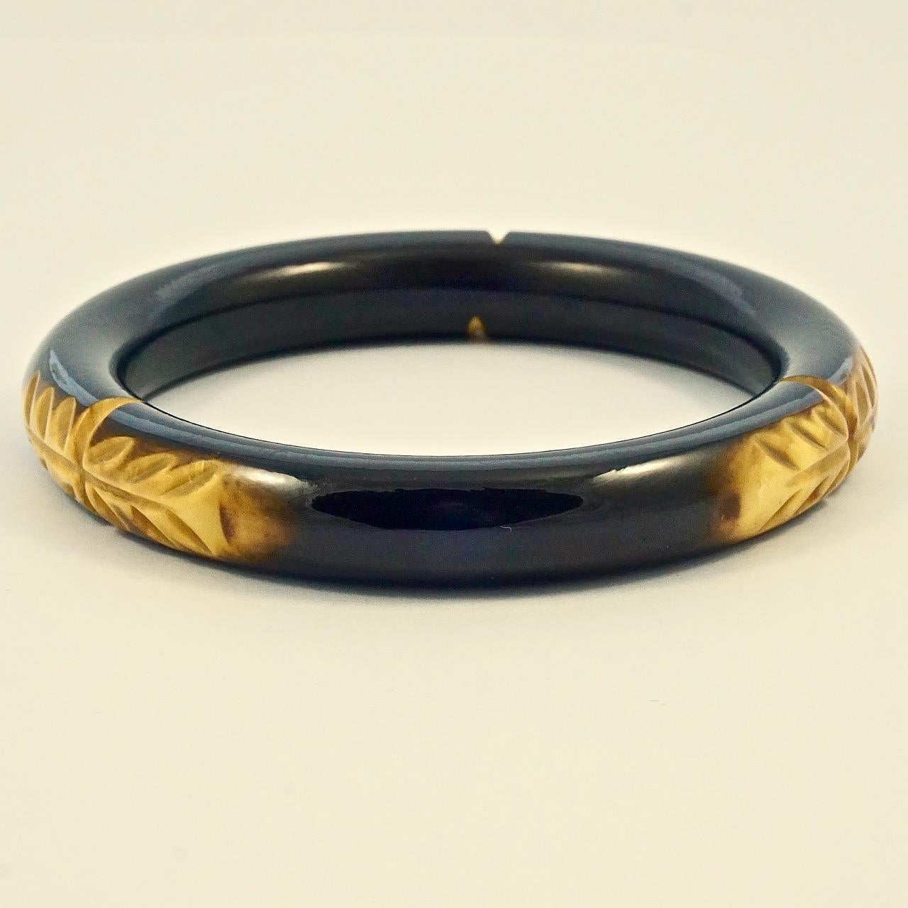 Meraviglioso braccialetto Art Deco in bachelite nera con intaglio di foglie gialle marmorizzate. Diametro interno 6,4 cm / 2,5 pollici e larghezza 1,1 cm / .4 pollici. Il braccialetto è in ottime condizioni.

Si tratta di un bellissimo braccialetto