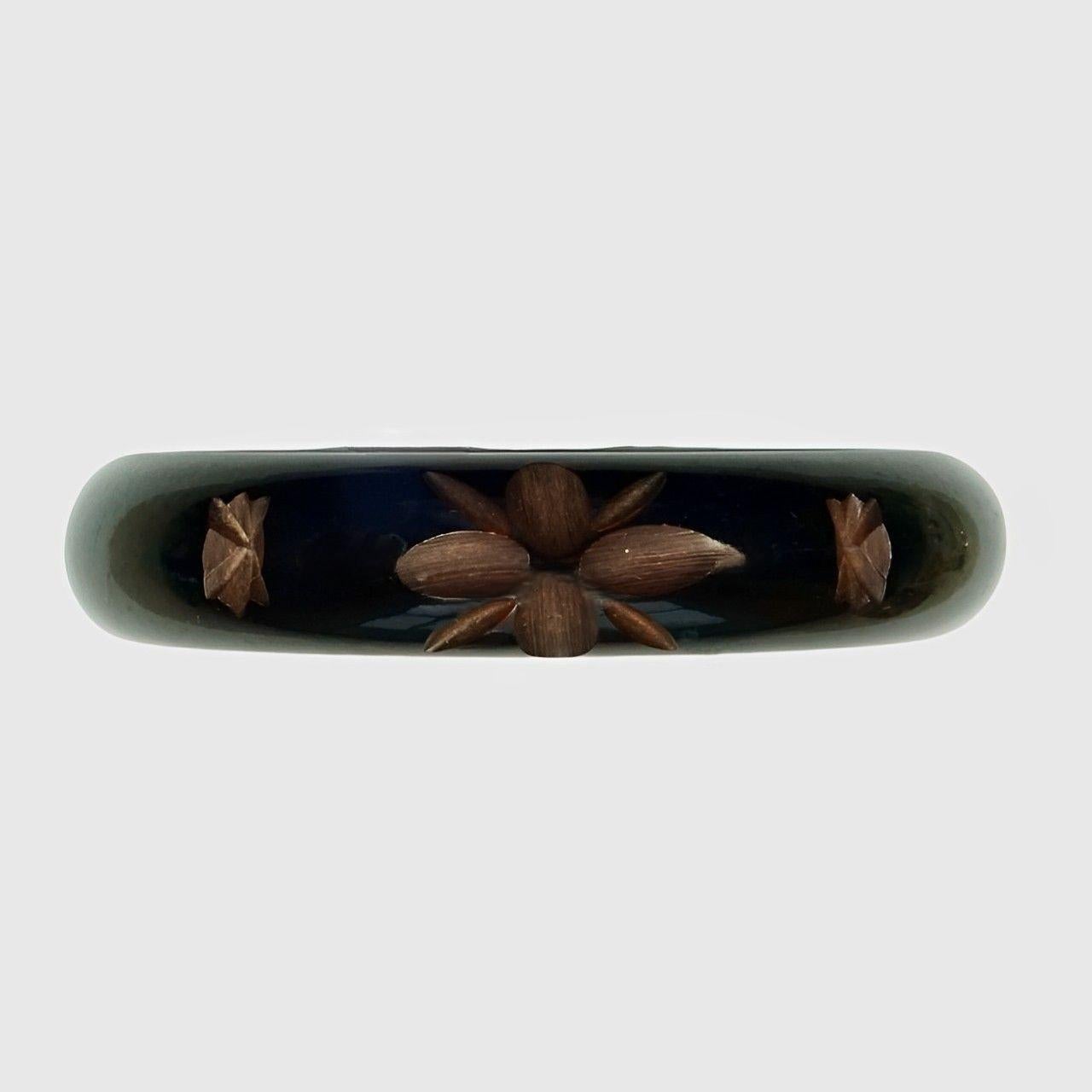 Merveilleux bracelet Art Déco en bakélite noire avec une sculpture abstraite de couleur brun moyen. Diamètre intérieur 6,4 cm / 2,5 pouces et largeur 1,55 cm / 0,6 pouce. Le bracelet est en très bon état, avec quelques rayures.

Voici un magnifique