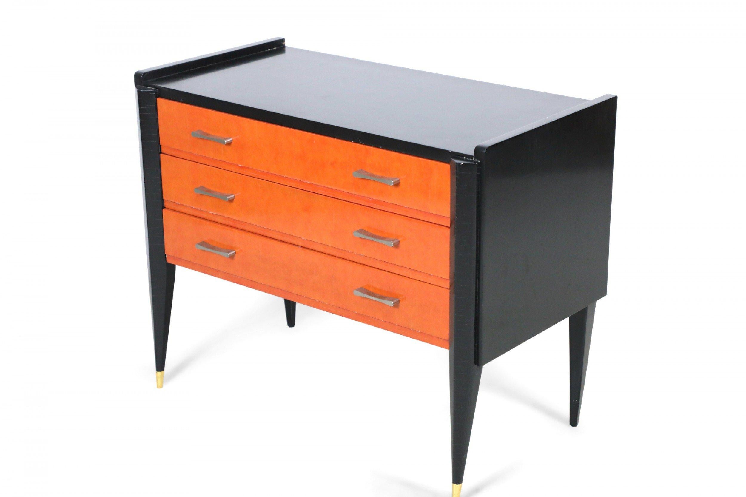 Cassettone a 3 cassetti in stile Art Déco laccato nero e arancione con gambe anteriori smussate e sabot in bronzo con tiretti in nichel.

Crepe nell'impiallacciatura su tutta la superficie, alcune scheggiature e perdite nella finitura.