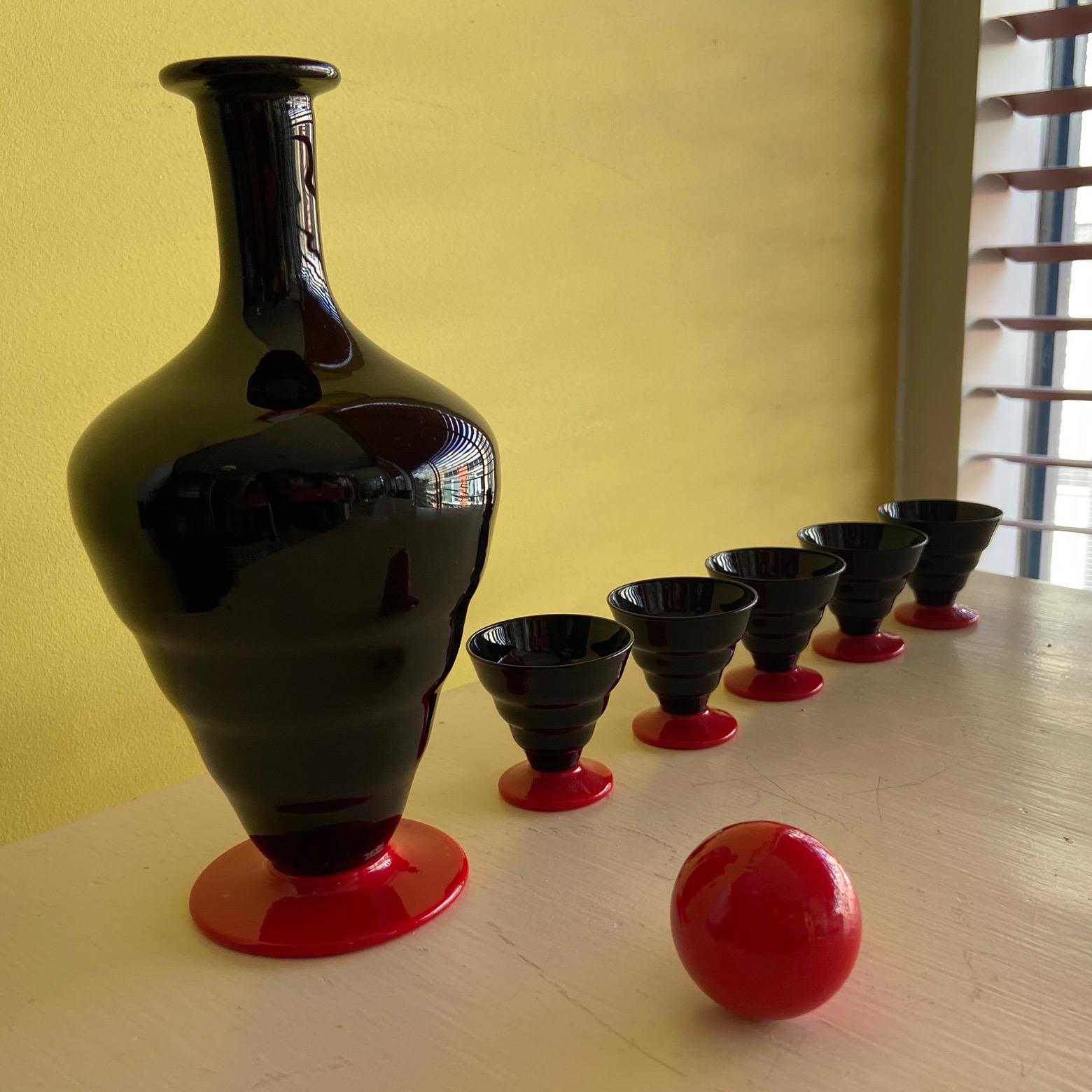 Service à liqueur Art déco en verre de Murano noir et rouge, carafe et 5 petits verres.
souvent attribuée à Venini, Murano.
carafe de 22 cm de haut
verres de 4,5 cm de haut.