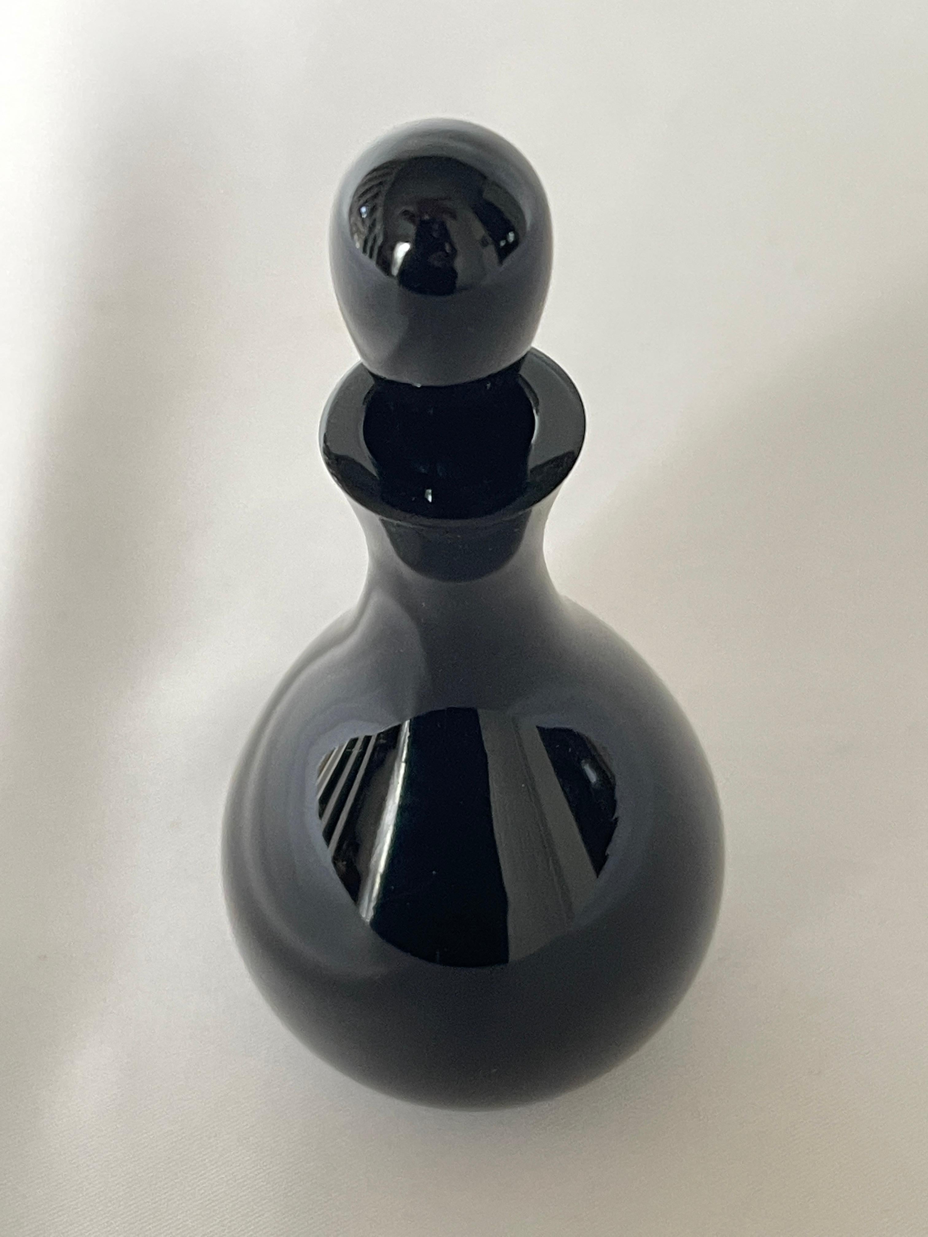 Flacon de parfum Art Déco en verre taillé noir avec bouchon.