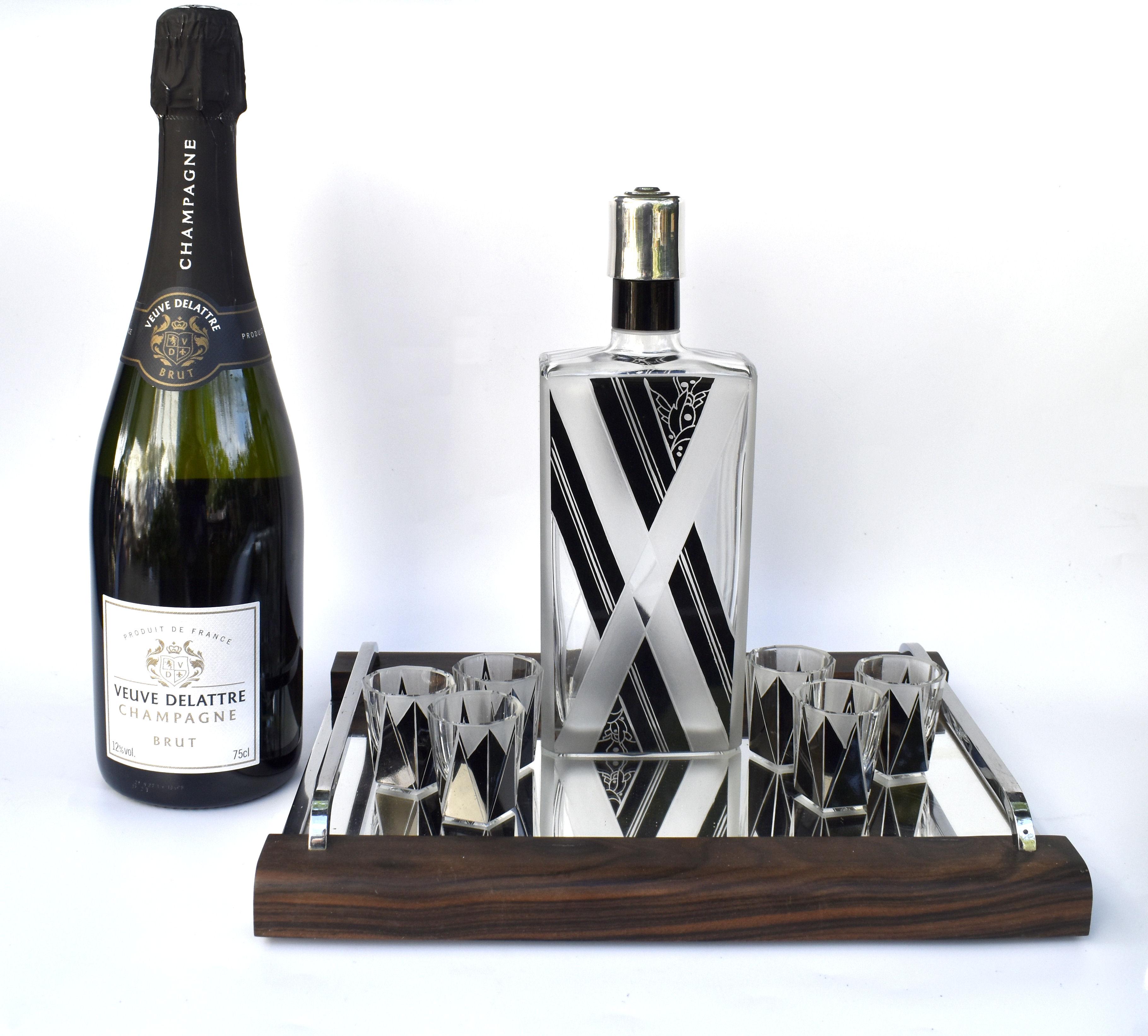 Wonderfully stylish is this Art Deco decanter set, ideal for this time of year either to gift or impress your guests. The decanter comes with six matching liquor glasses. The whole being heavily enamelled with geometric design and etched. The jet