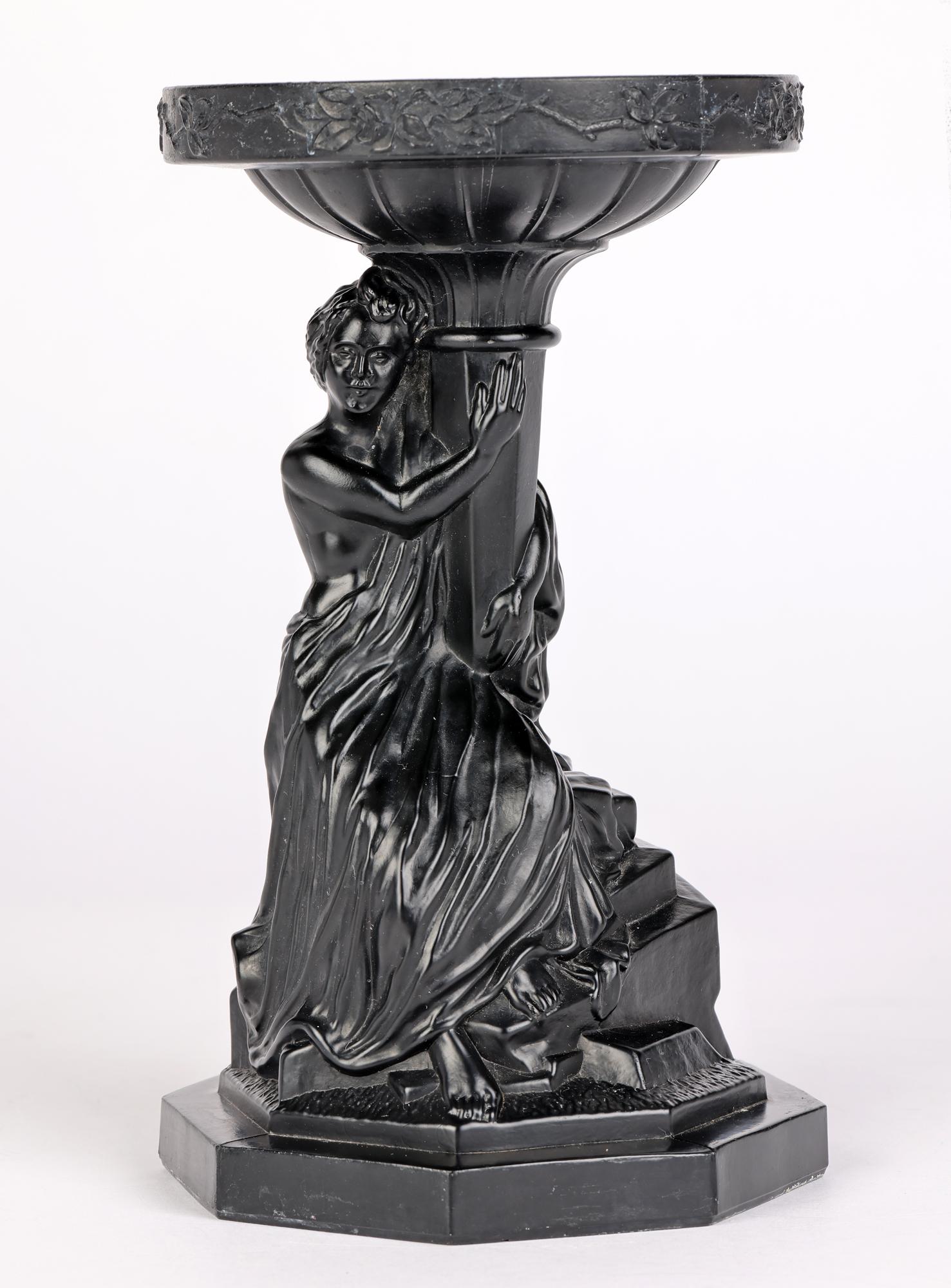 A very unusual and good quality molded black glass stand with the classical figure of a seated lady, the stand supporting a large round white polished rock crystal ball and with date marks for 1930. The stand is well made standing on an octagonal