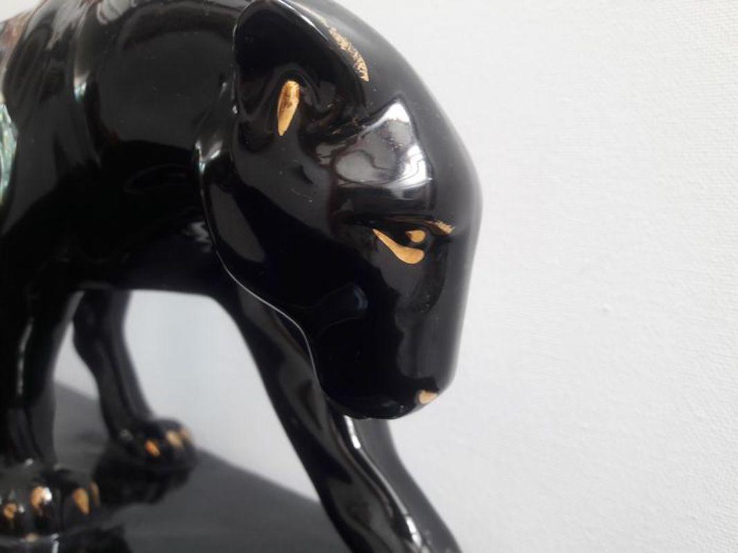 Art Deco black and gold varnish ceramic panther Signed Jean, from France from 1930s period. This sculpture, very realistic, represents a black panther approaching its prey slowly and quietly. There are some details which are in gold lacquer such as