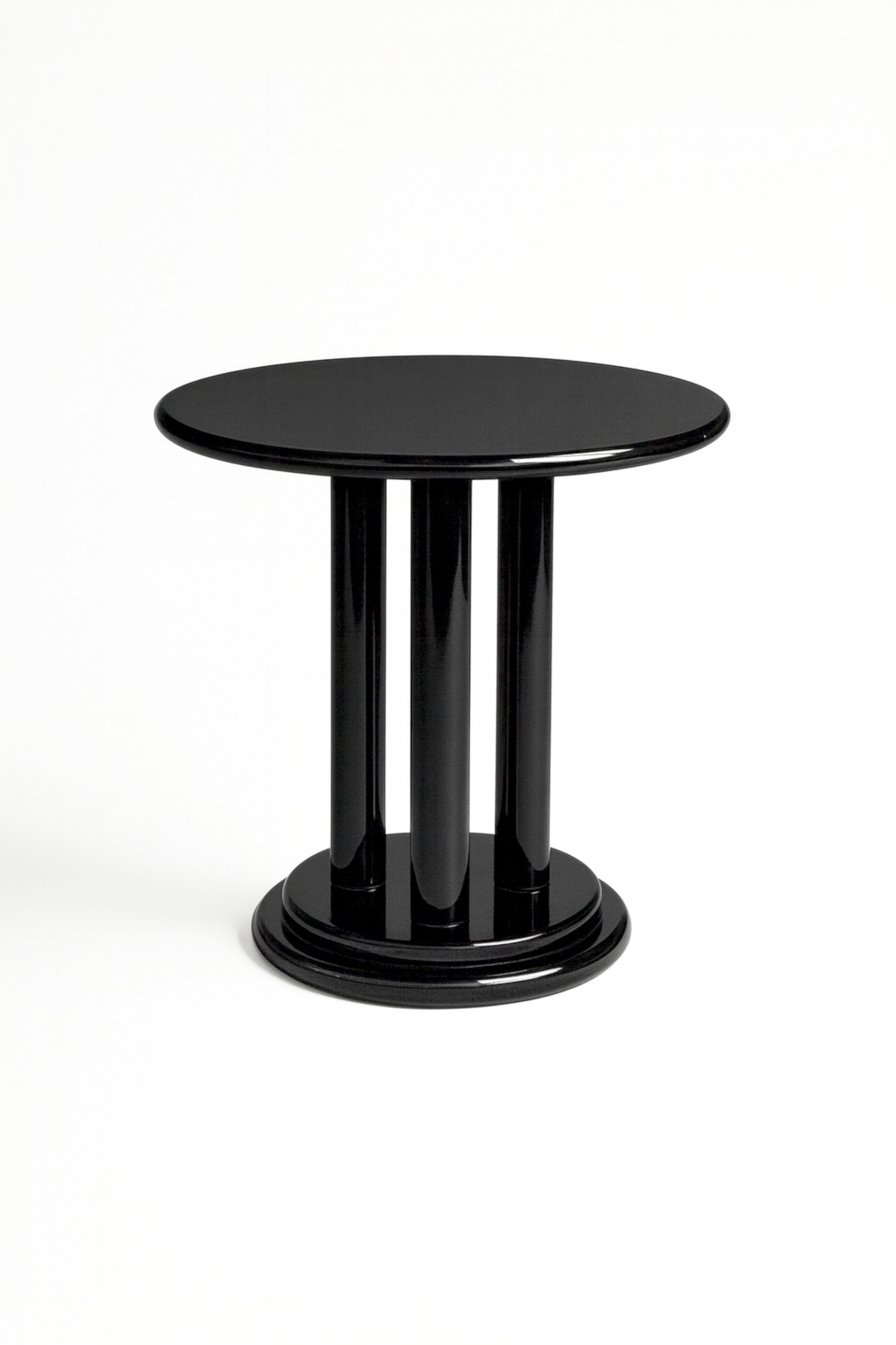 Aggiungi un versatile tavolo rotondo di colore nero laccato, ideale per molteplici usi e soluzioni di design dello spazio. Caratterizzato da tre gambe in legno arrotondate e da una base circolare, questo pezzo combina la funzionalità con un'estetica