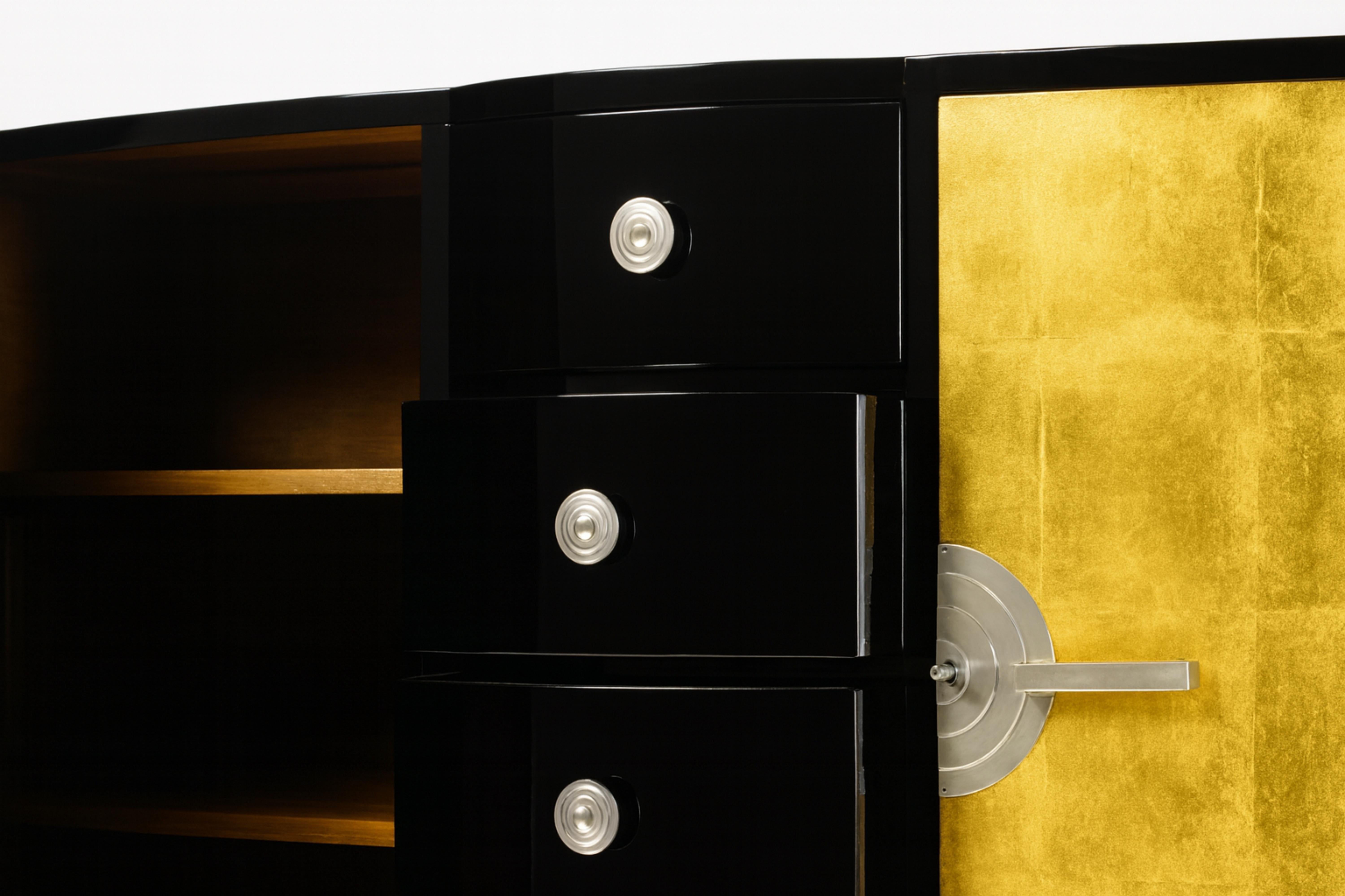 A large 1940s Art Deco sideboard credenza features a remarkable gilt work and a black varnish rework. It has a spacious cedar interior with two doors and four drawers for dinnerware and cutlery. The piece is accented with nickeled brass hardware.