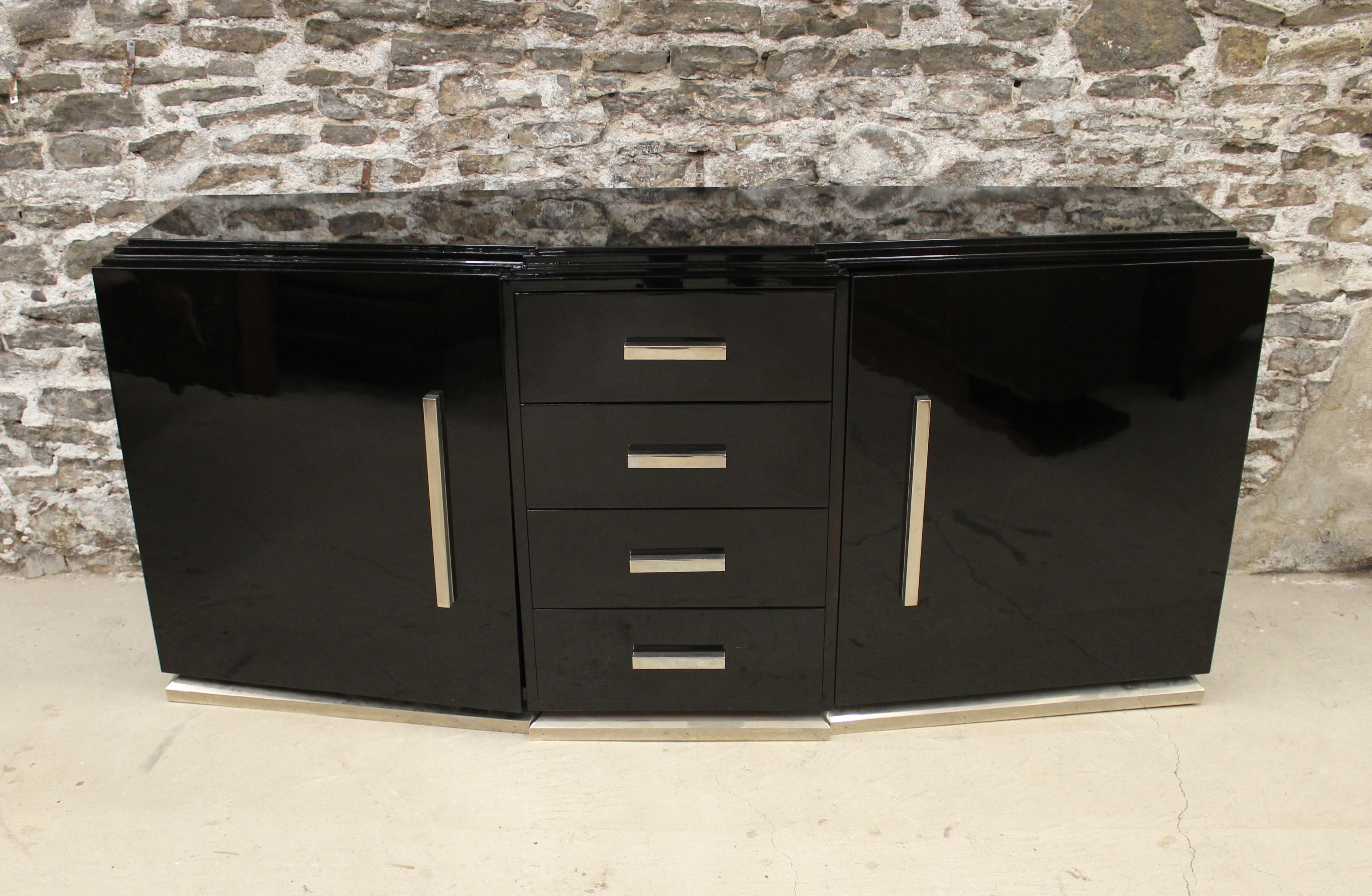 Art Deco black lacquer sideboard with two-door slanted front flanking four drawers with heavy squared chrome hardware.