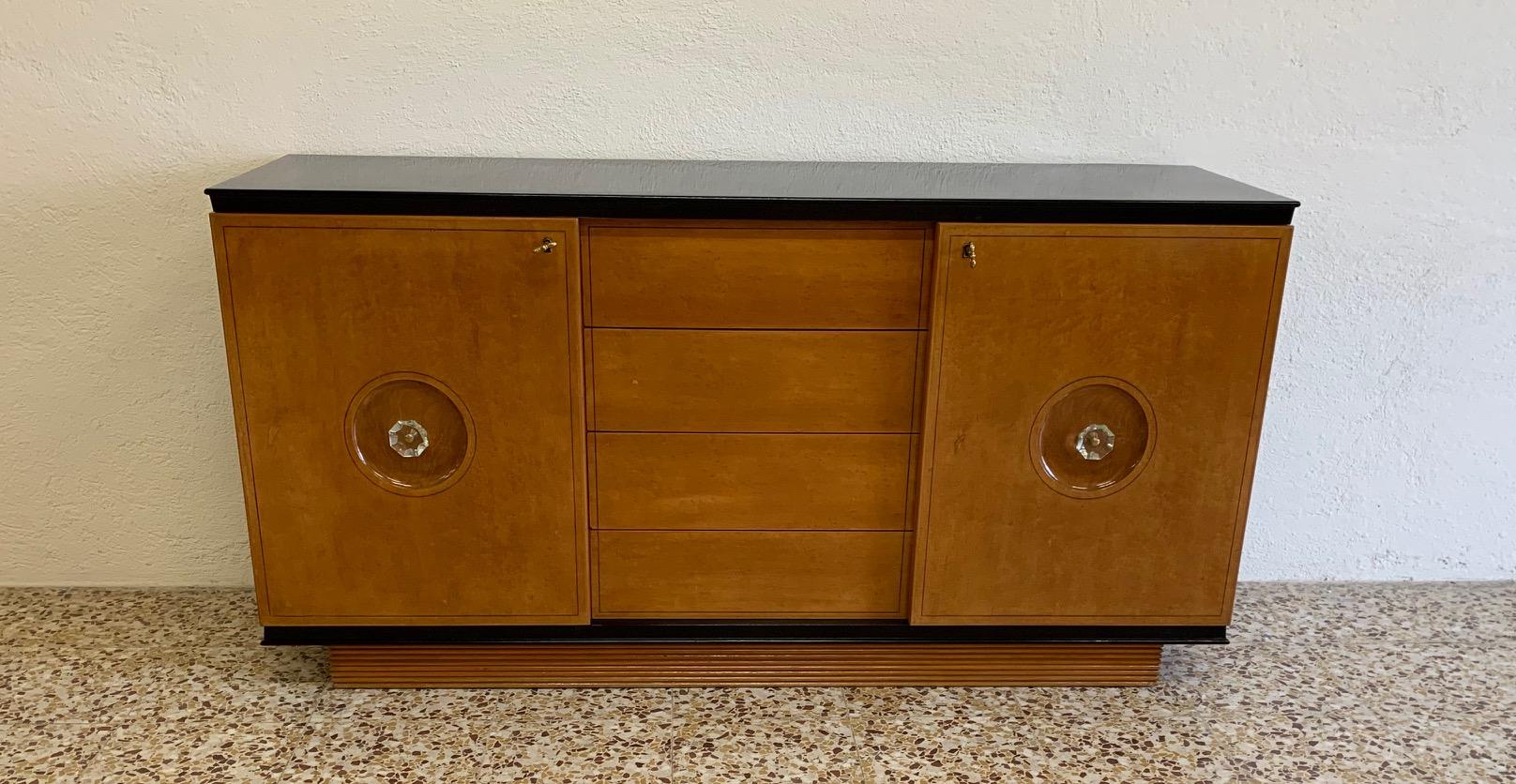 This Art Deco dresser was produced in Italy in the 1940s.
The front and the profiles are in maple while the structure is finely black lacquered.
The original handles are in glass and brass.
The elegant walnut interior has four drawers and two