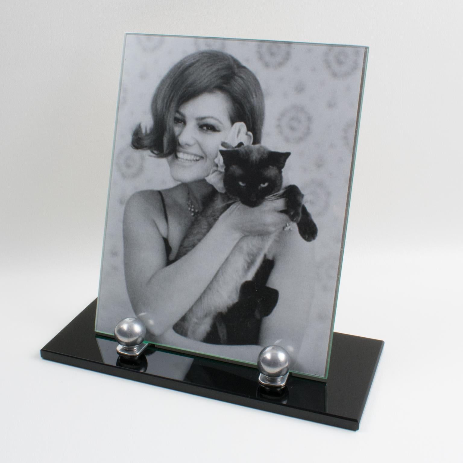 This lovely French Art Deco picture photo frame features a thick black opaline glass plinth complimented with two polished aluminum metal holders and aluminum bead accents. The frame has a glass sheet on the front and an aluminum sheet at the back