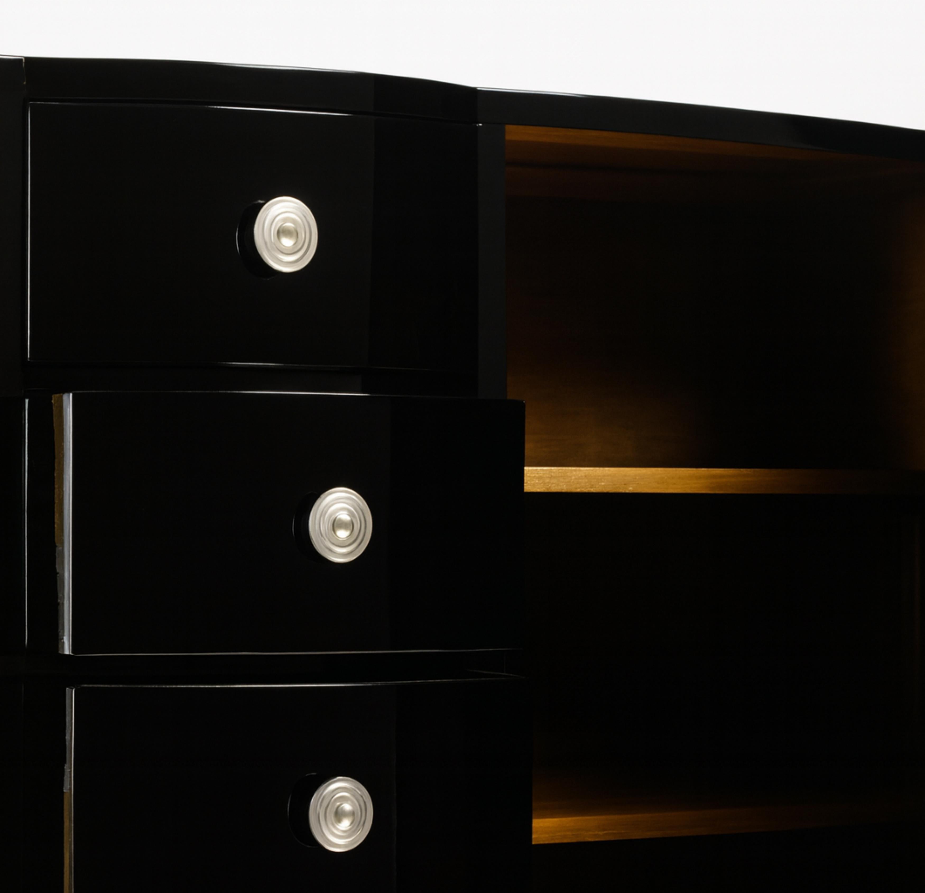 A large 1940s Art Deco sideboard credenza features a remarkable black color refinishing. It has a spacious cedar interior with two doors and four drawers for dinnerware and cutlery. The piece is accented with nickeled brass hardware.