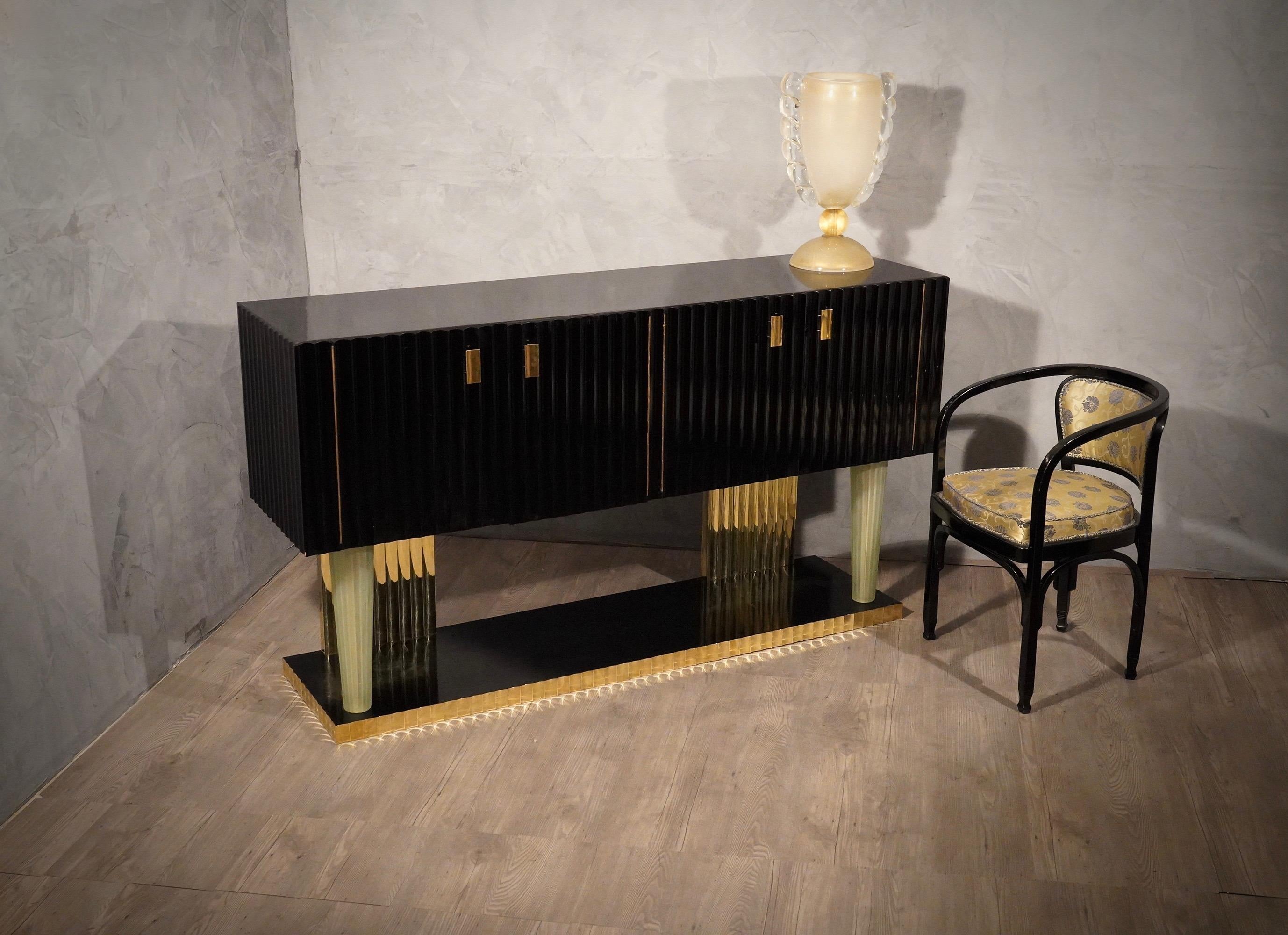 Jewel sideboards of the Art Deco period, fascinating the type of construction, with very precious materials, Murano glass, brass and black polished wooden shells.

The sideboard has a wooden structure polished in black shellac, as you can see from