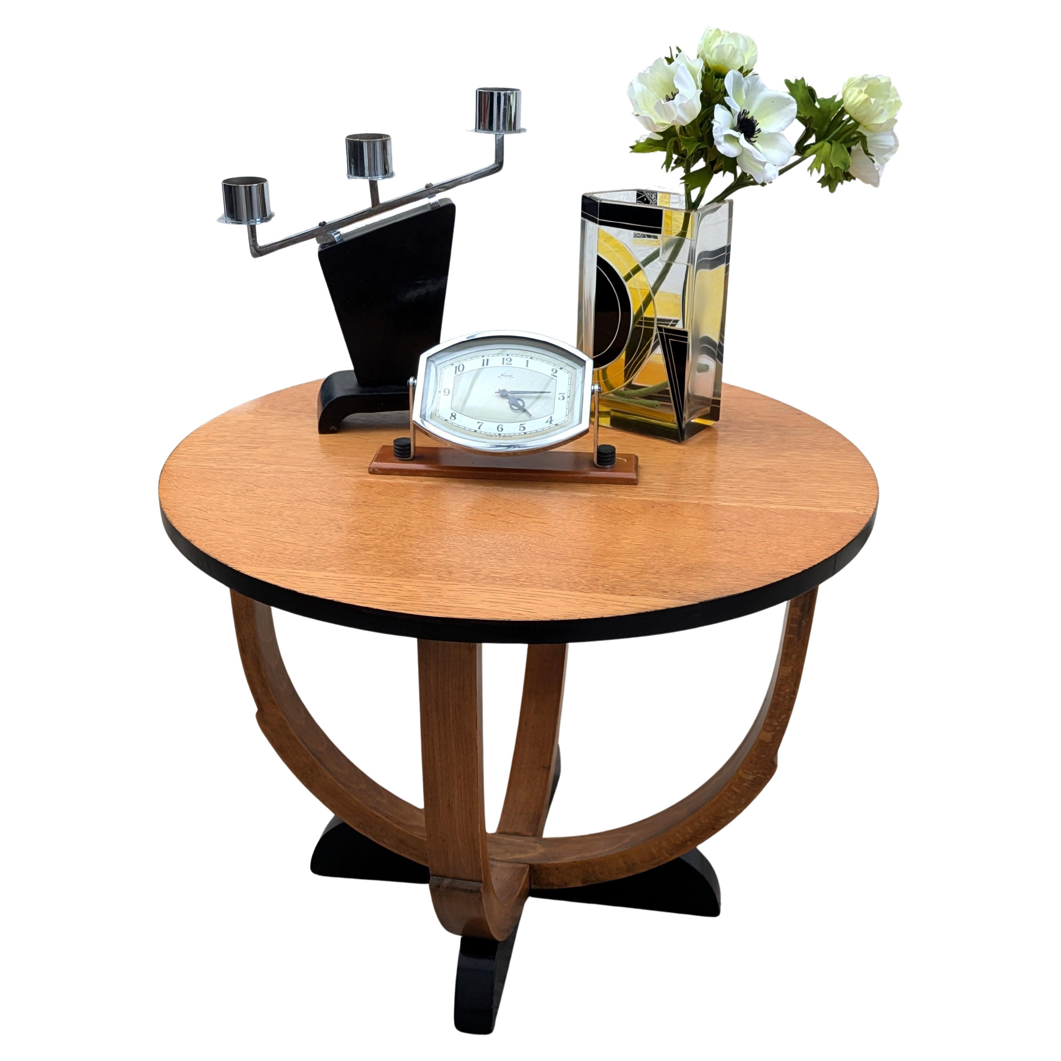 Table d'appoint Art Déco élégante et totalement authentique datant des années 1930. Cette table en chêne blond aux tons clairs possède quatre pieds qui descendent jusqu'à quatre pieds ébonisés, ce qui en fait une pièce très attrayante et très