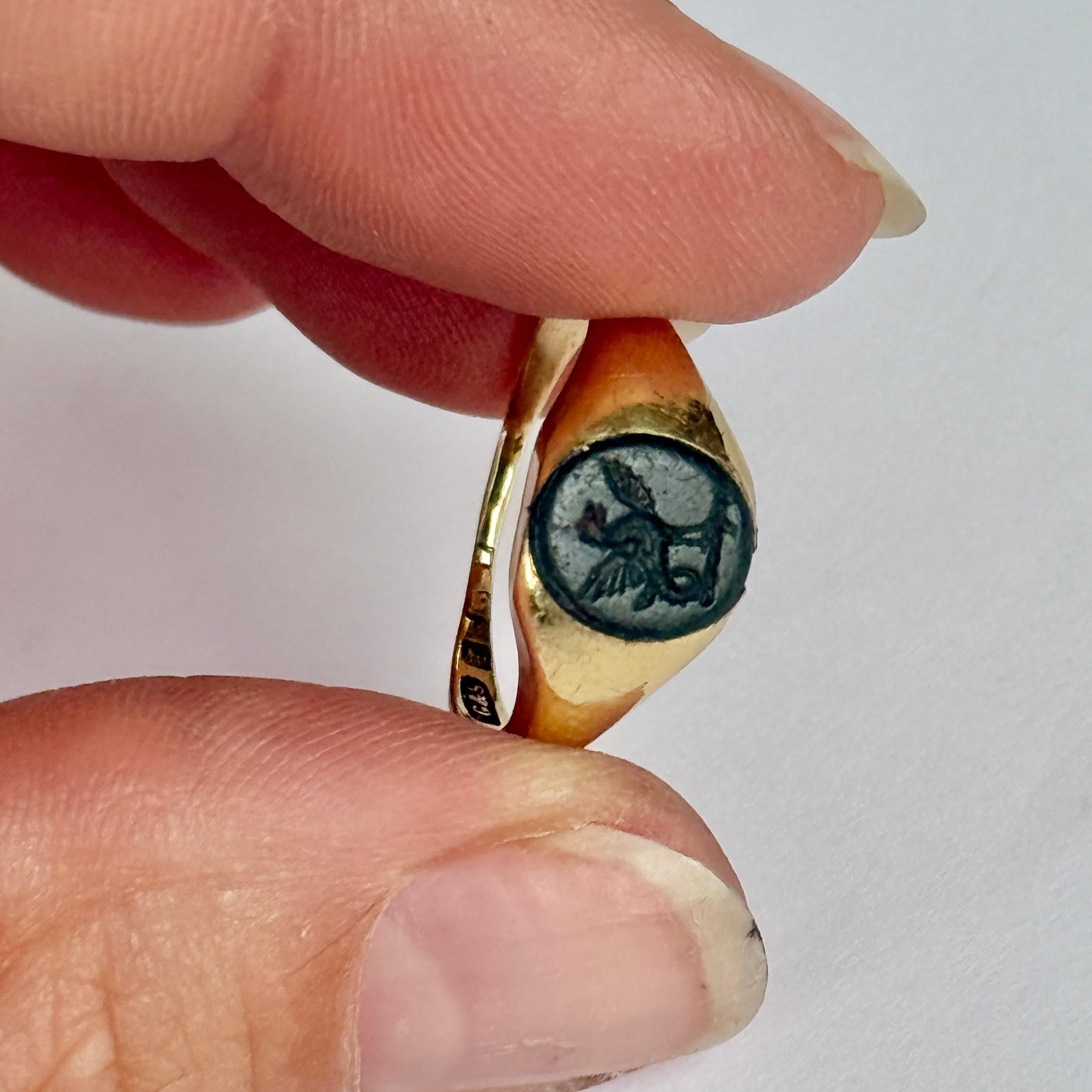 This signet ring has a bloodstone set within the 18 carat gold band. The stone is deep green and has a griffin engraved into it. 

Ring Size: J or 4 3/4
Stone dimensions: 9x7.5mm 

Weight: 2.8g 