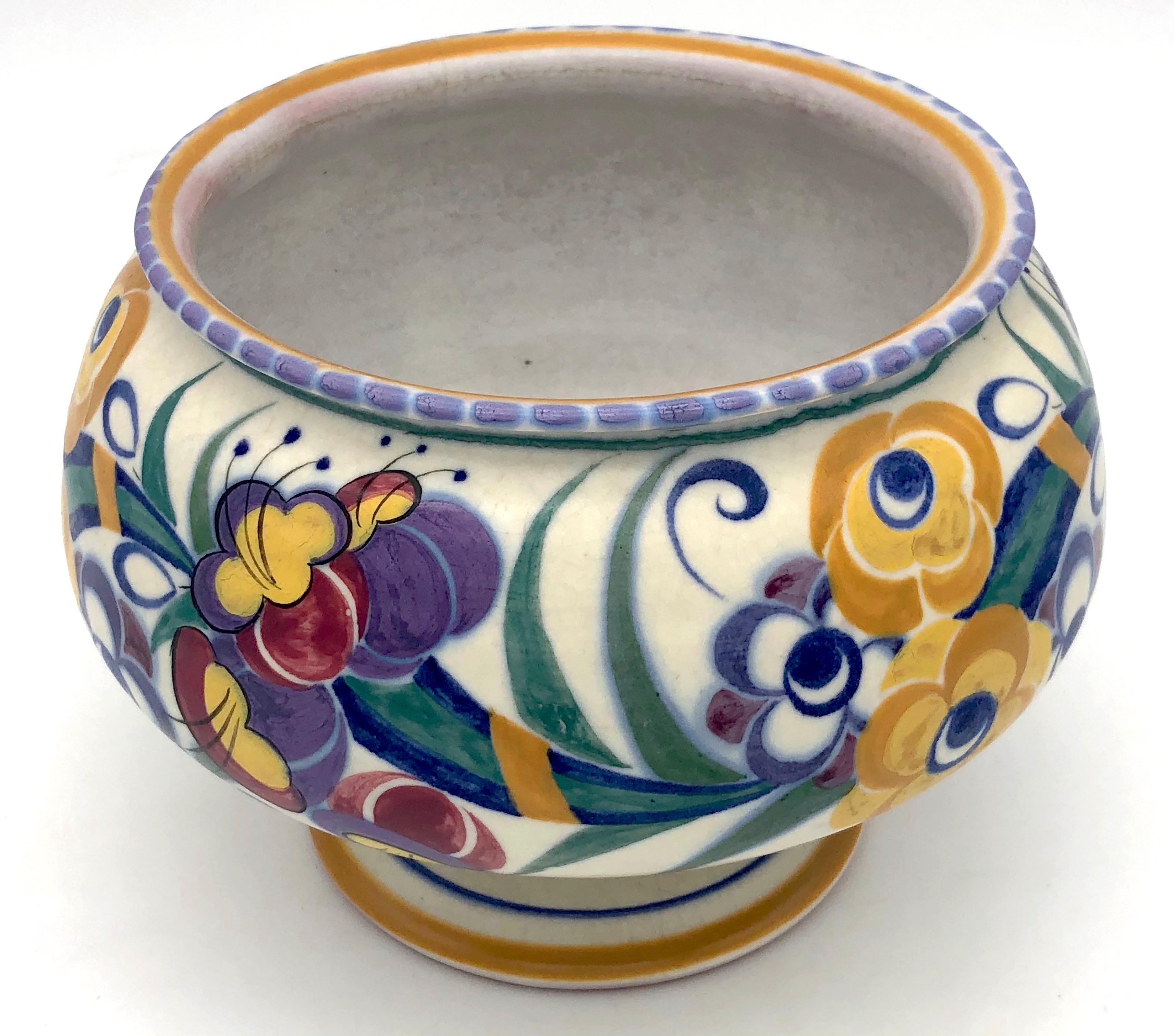 This bright coloured hand brush painted piece of Art Deco studio pottery was made in the second half of the 1920's.
The early decorative ceramics were made from red earthenware and have red, unglazed bases.
These red bodied pieces are considered