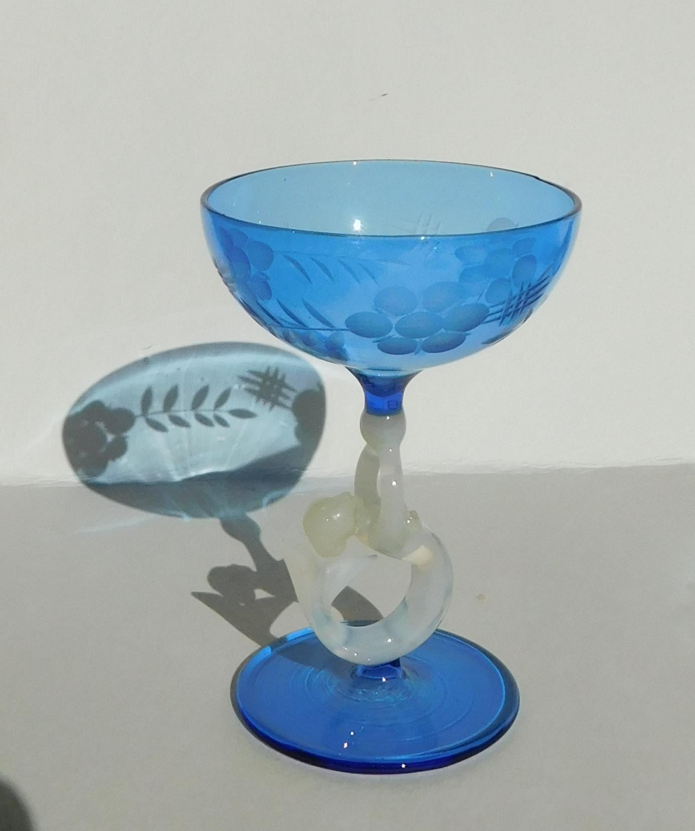 Jarra Art Decó Bimini con juego de ocho vasos a juego. Soplado a mano en azul y decorado con sirenas blancas. Se ve uno tanto en el decantador como en el tapón. Muy delicado pero sin daños. Este juego se fabricó en la década de 1920 en Austria y