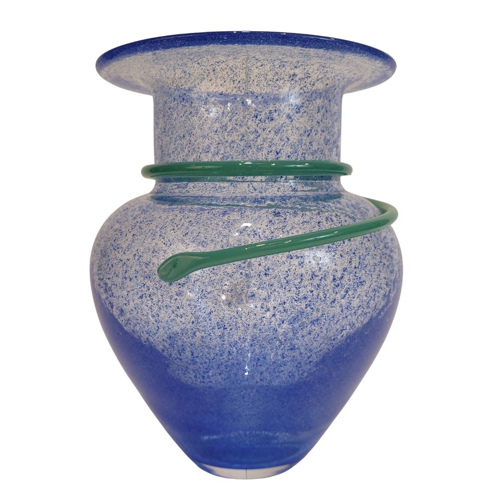 Remarquable vase en verre soufflé, œuvre de l'artiste et designer suédoise Monica Backström pour Kosta Boda. Une surface bleue qui joue sur l'intensité et la transparence. Une forme serpentine, de couleur vert d'eau, s'enroule autour du col de la