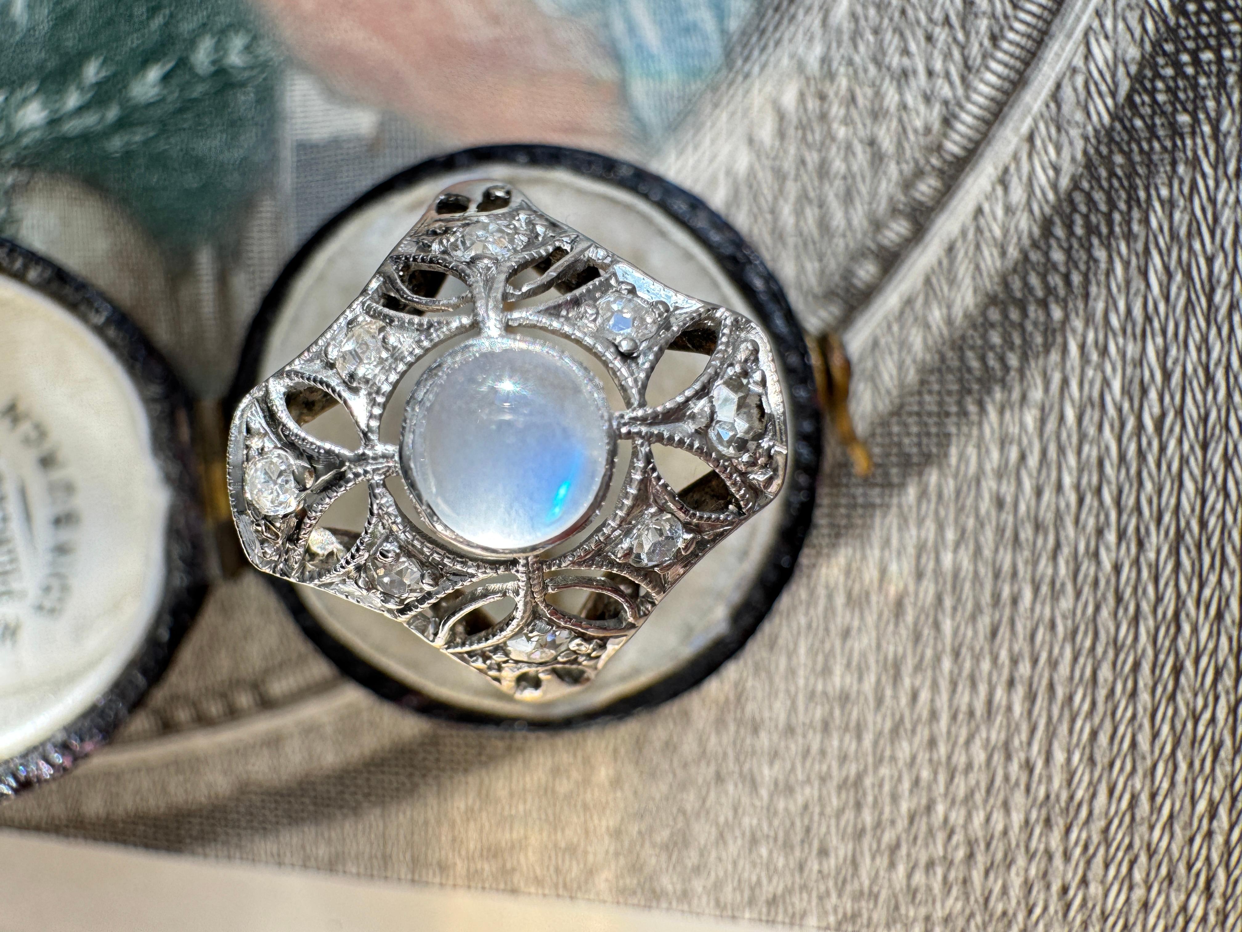 This charming Art Deco ring features a luminous blue flash moonstone set atop a gently domed platinum setting, accented by eight sparkling single-cut diamonds. Circa 1920s-30s. Currently a ring size 5.5

Weight: 2.3 grams

Diamonds: eight single-cut