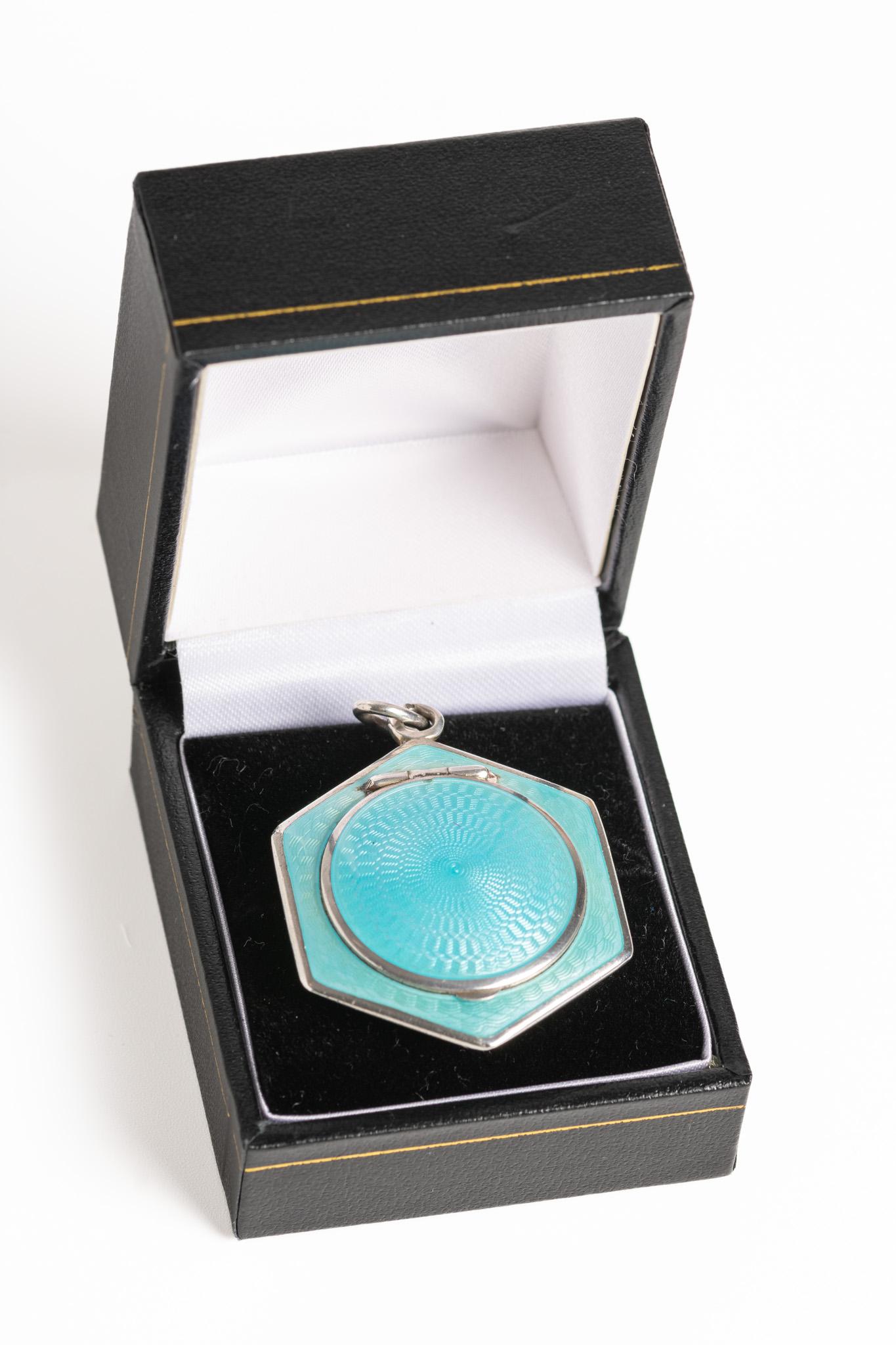 A magnificent and rare Austrian Art Deco blue guilloche enamel and silver gilt mirror hexagonal locket. This beautiful piece is made in aqua blue guilloche enamel with a silver gilded interior. The locket has a lovely, small mirror inside and it's