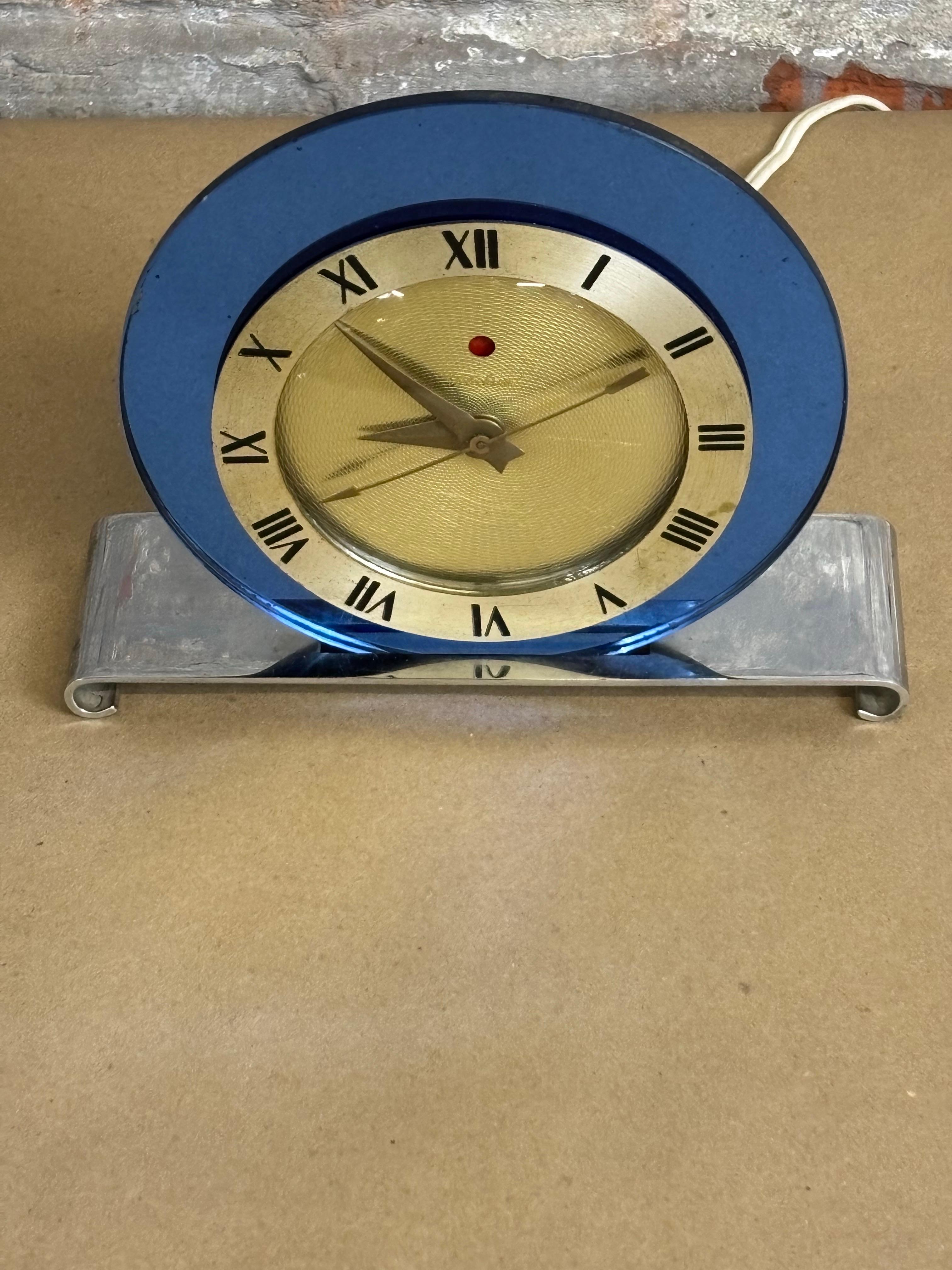 Blue Mirror and Chrome Table Clock.  Overall nice original condition!  Clock was opened up and all glass was cleaned.  Typical art deco Clock face makes this model a true classic!  Mirror is nice and original!  Been plugged in and currently running
