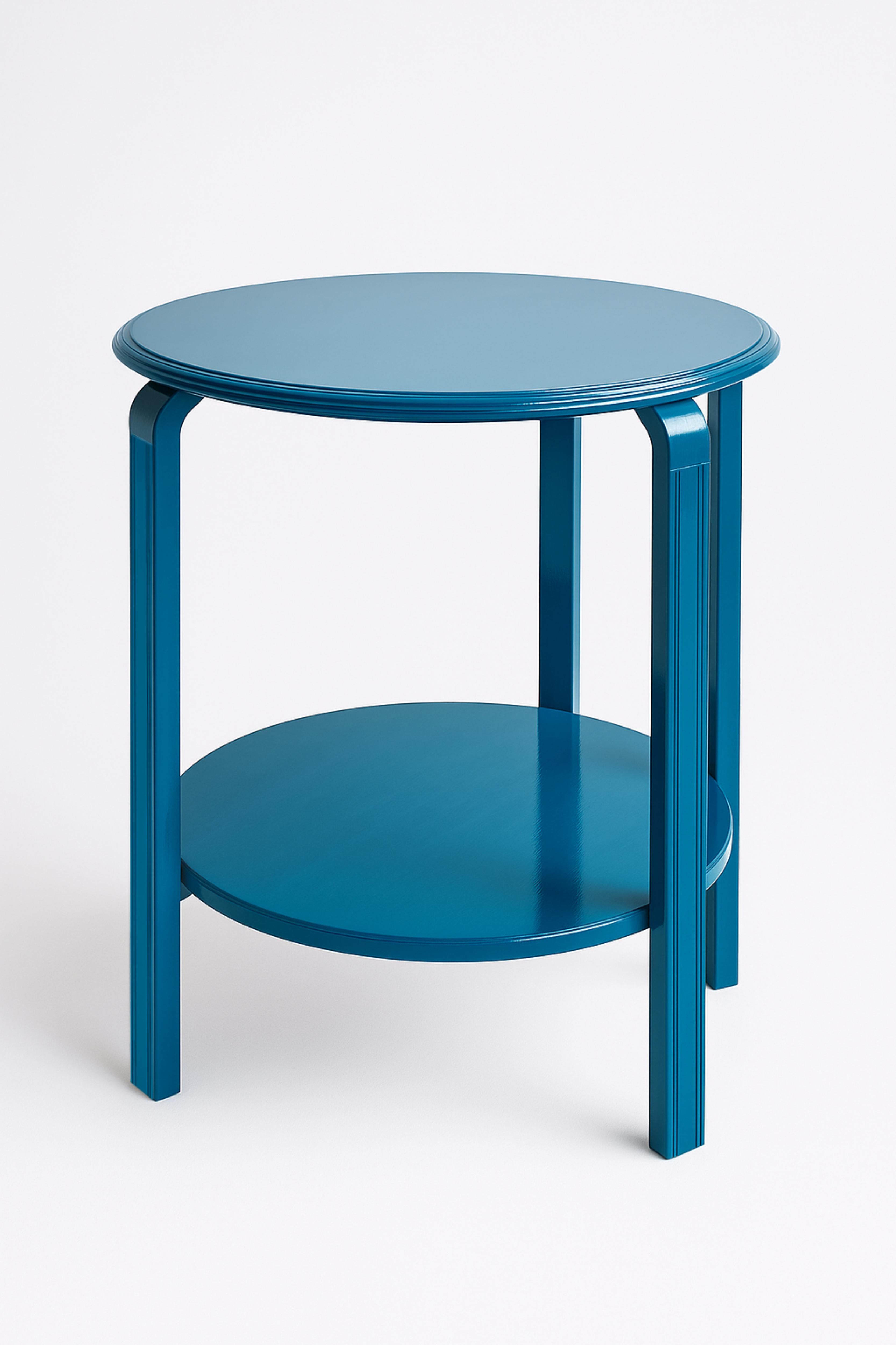 Mesa auxiliar redonda Art Déco azul pavo real. Esta mesa cuenta con un estante, que añade estilo y funcionalidad extra para almacenaje o exposición.

Altura: 63 cm (24,8 pulg.)
Diámetro superior: 48,5 cm (19,1 pulg.)
Diámetro del estante con patas: