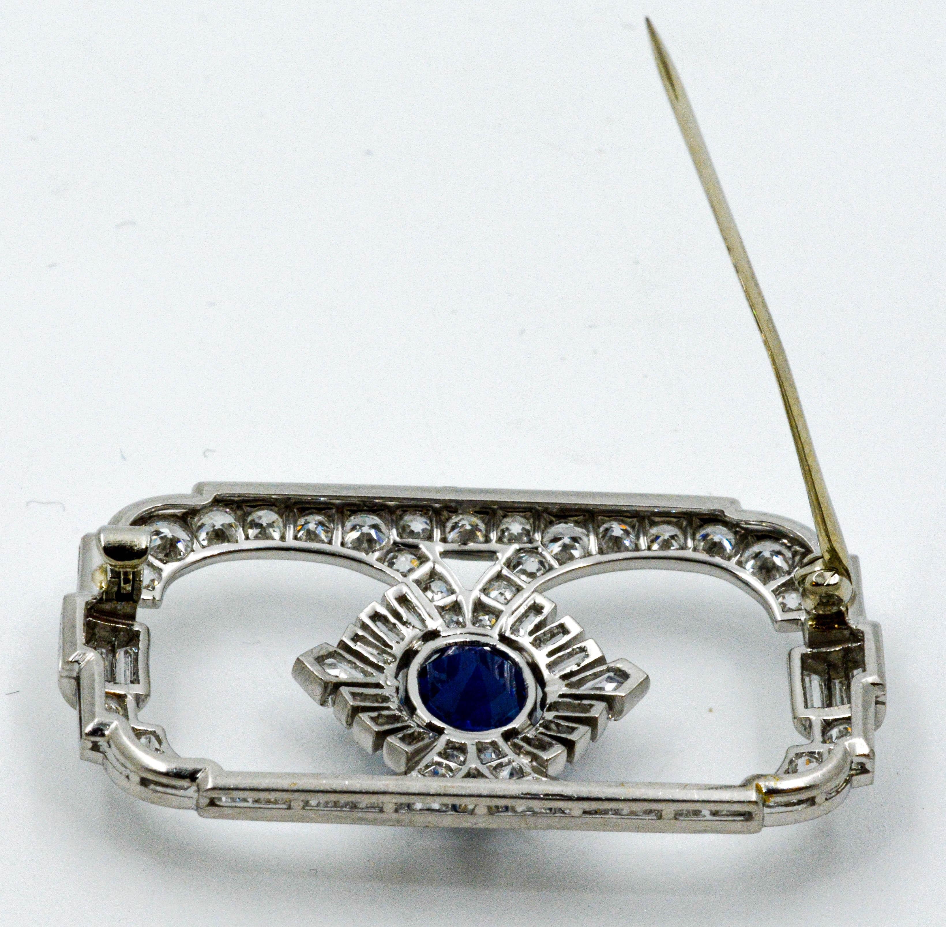 A stunning platinum Art Deco blue Sapphire and diamond brooch created Circa 1980's. An exquisite  2.85 carat round blue Sapphire is set as the center piece of this pin, and is surrounded creatively with 54 transitional cut diamonds weighing