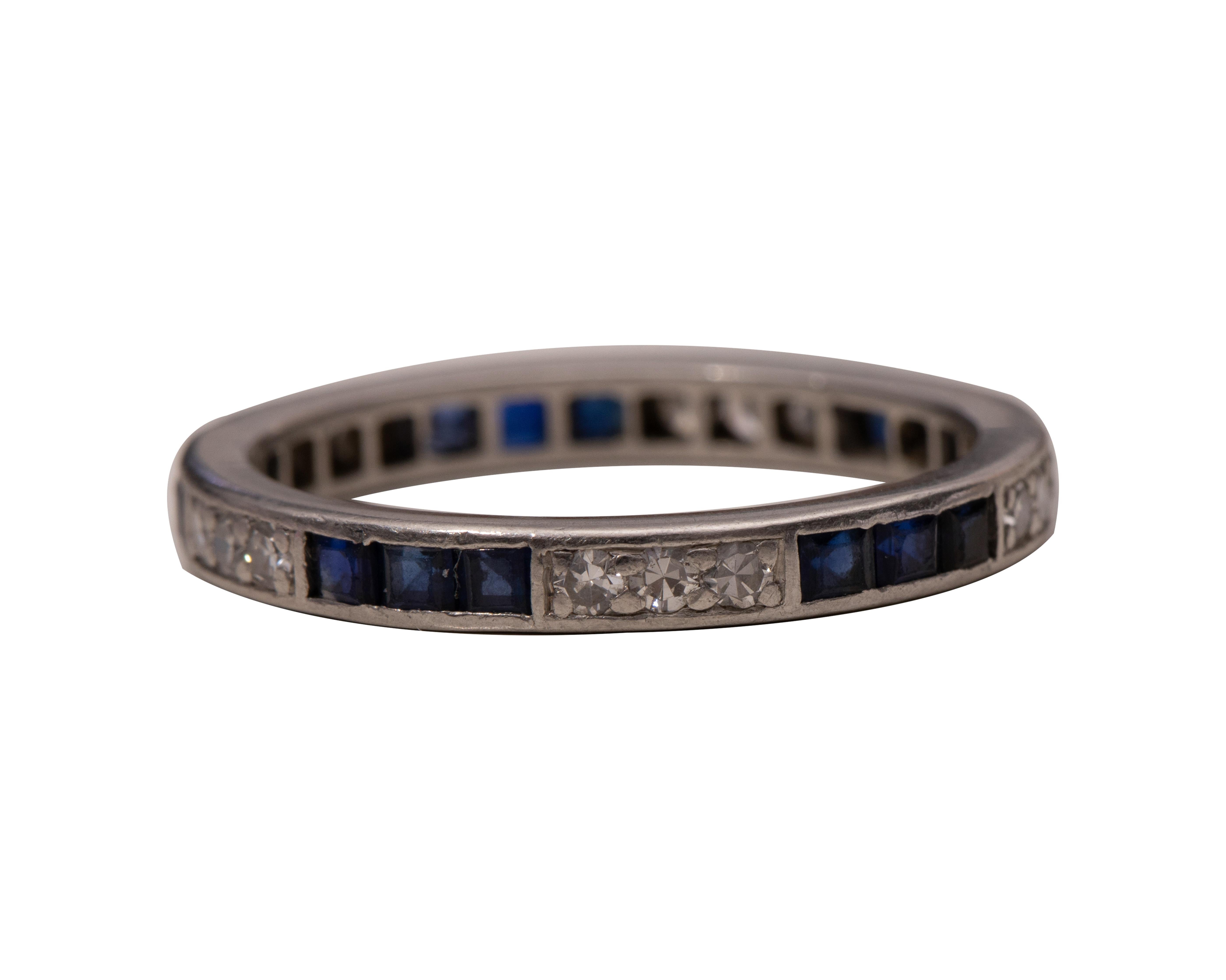 This piece is a genuine 1920s era Art Deco eternity band featuring a stylish pattern of alternating sections of diamond and blue sapphires set in platinum! There is a pierced open back pattern throughout the ring to allow light and brilliance to be