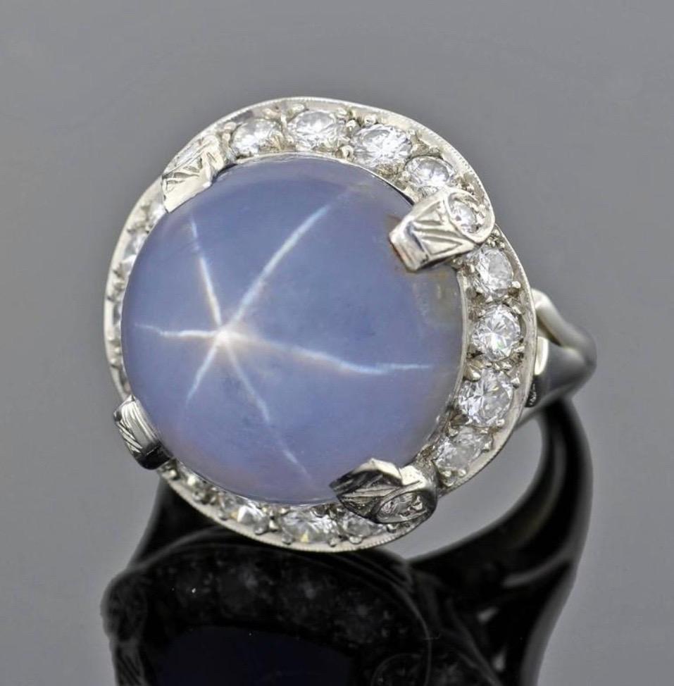 1930s Late Art Deco 12 Carat Star Sapphire Diamond 18 kt White Gold Cocktail Ring

This cocktail ring has a large, natural star sapphire that is a round cabochon shape. The stone weighs 12+ ct and has a rich blue color. it is surrounded by 16