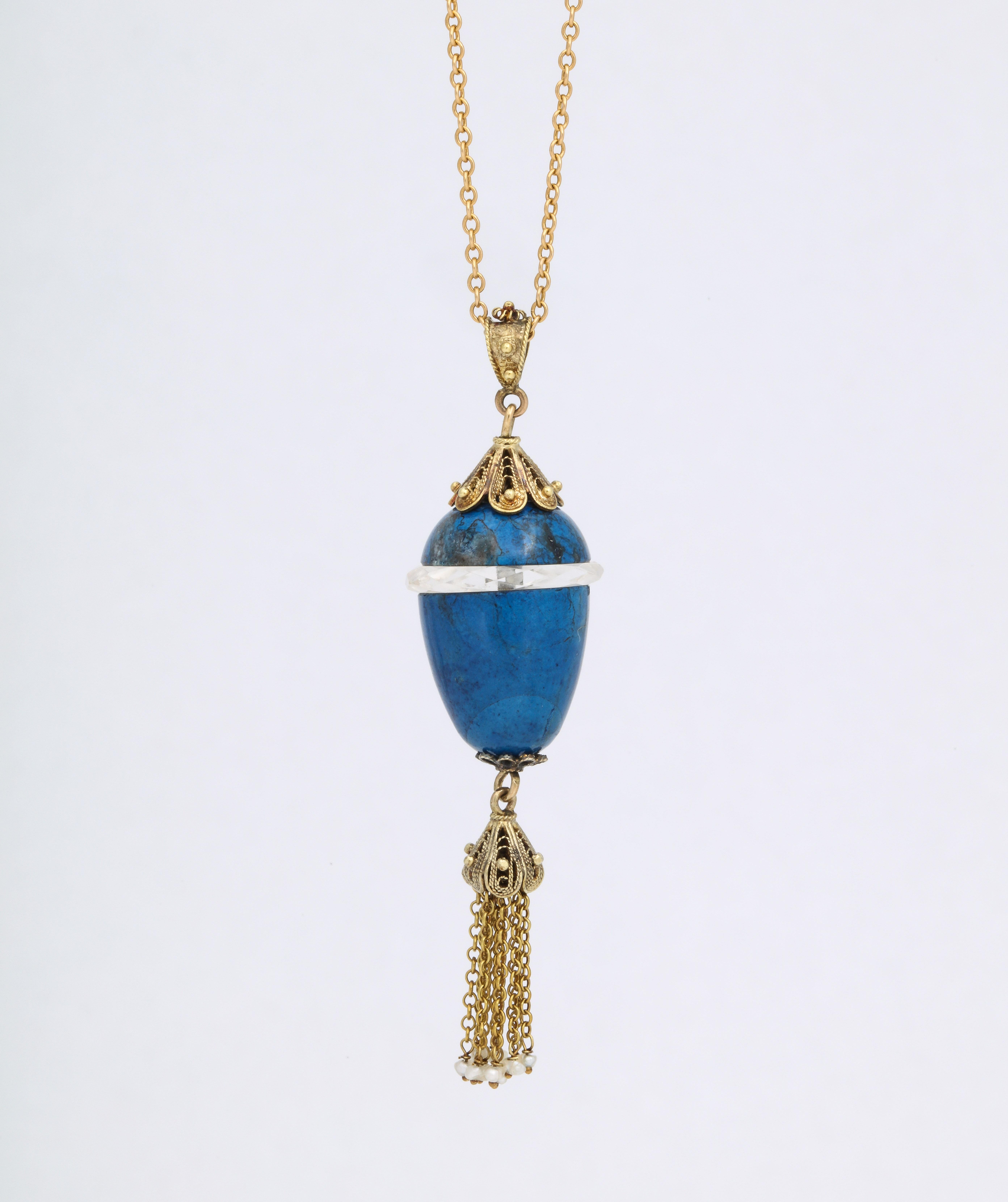 .So much detail is in this delicious color blue sodalite and crystal egg necklace that swings from its 10 Kt chain. A. crystal band is directly at the egg center. The top cap is a dainty filigree with gold beads. A similar accent is at the bottom of